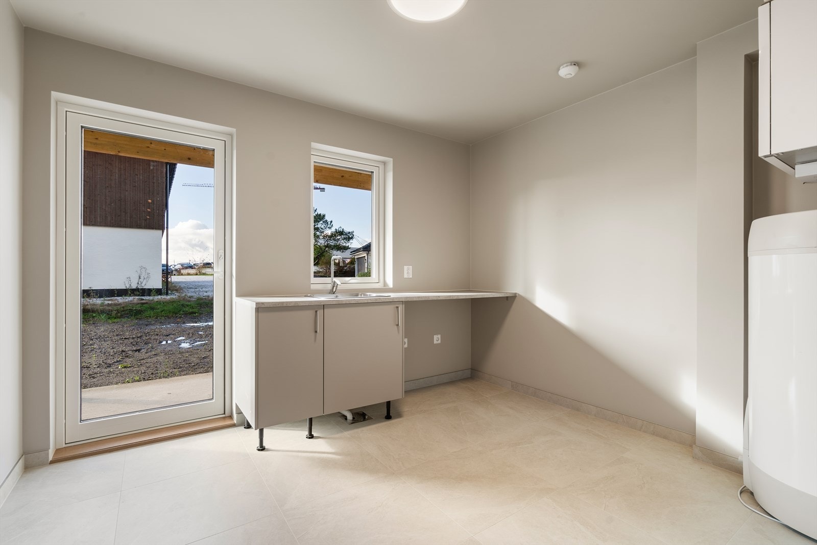 Romslig vaskerom med helfliset gulv. God plass til å tørke klær og oppbevaring Galleribilde