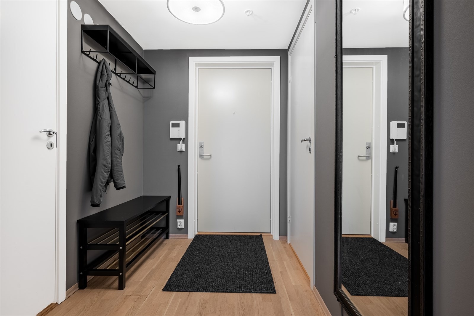 Romslig entré med knaggoppheng og dørcalling. Galleribilde