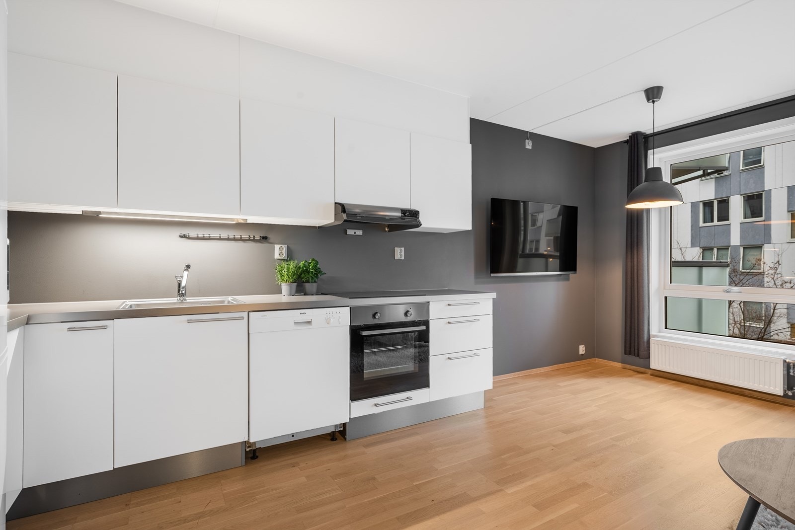 Kjøkkeninnredningen har hvite, slette fronter og laminert benkeplate. Galleribilde