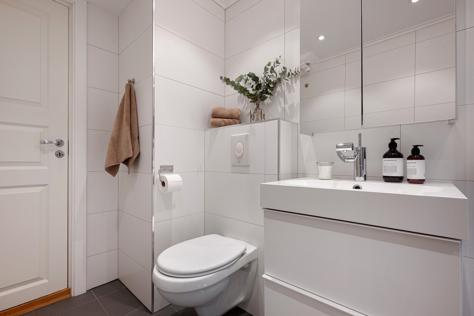 Rommet er helfliset med store, lyse fliser på vegg og grå fliser på gulv med komfortabel gulvvarme. Galleribilde