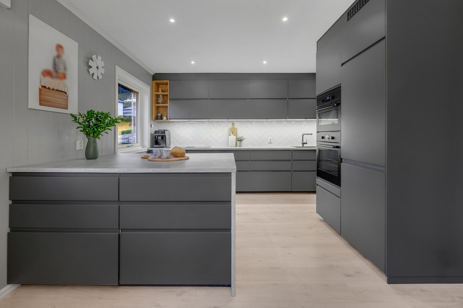 - Lekkert kjøkken med slette moderne fronter, integrerte hvitevarer og en romslig øy for matlaging. Galleribilde