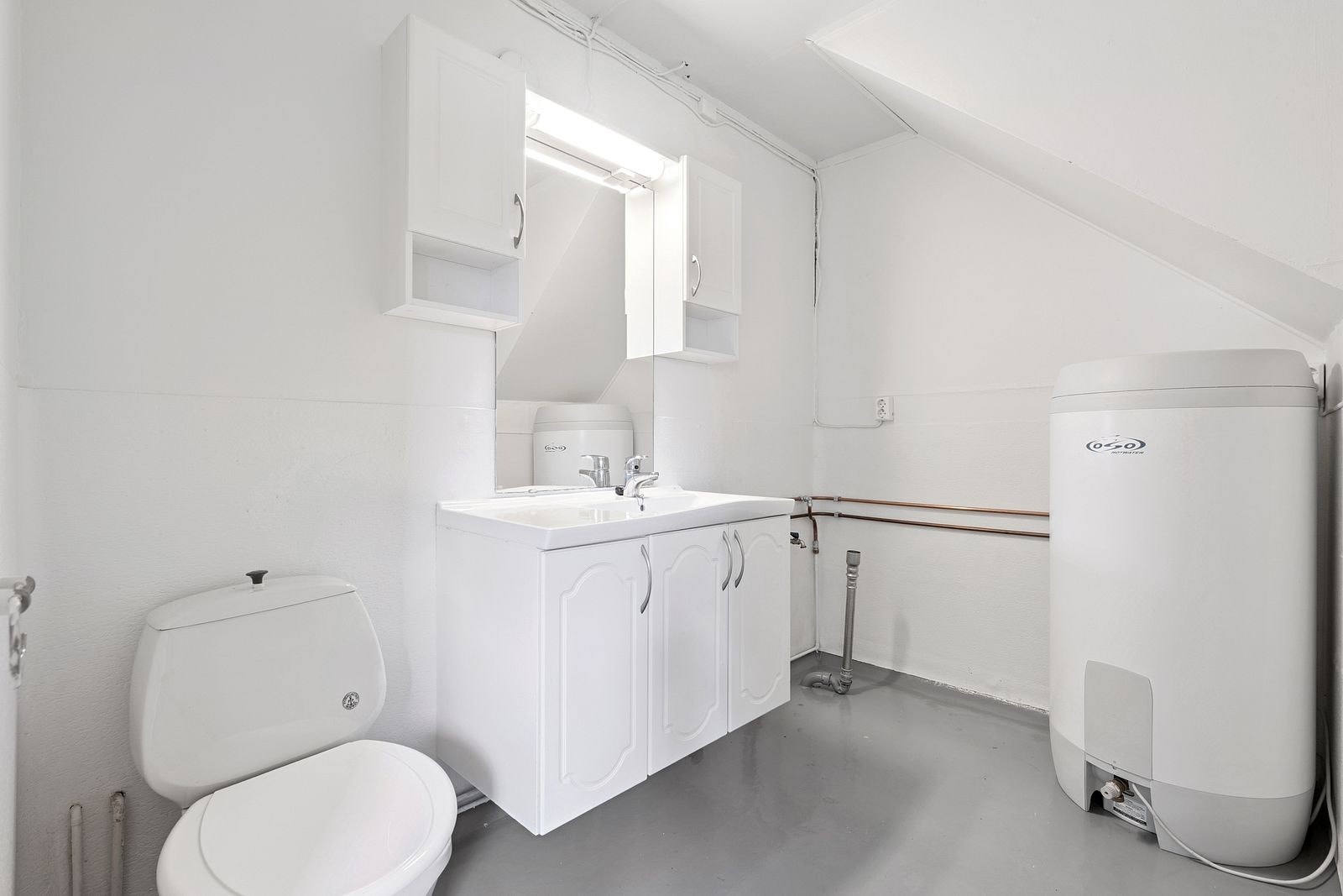 Et noe eldre baderom med muligheter for vaskemaskin og tørketrommel. Det er praktisk å ha to bad i en enebolig. Galleribilde