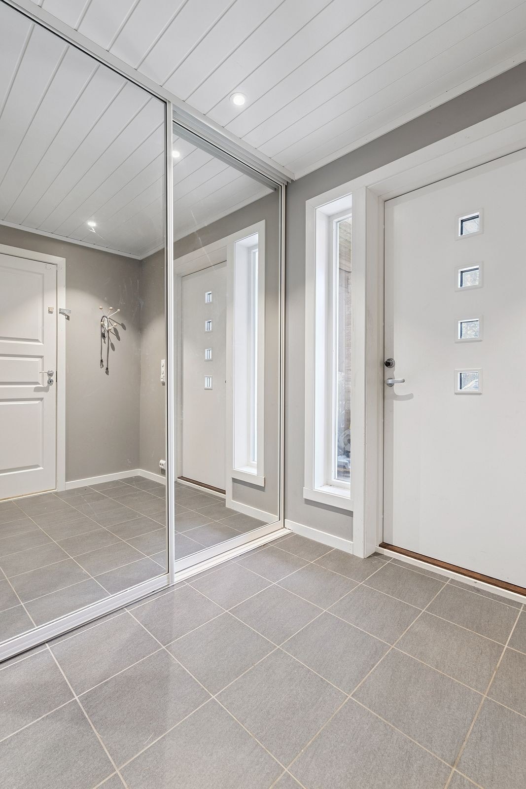 Velkommen inn! Praktisk skyvedørsgarderobe for å henge fra seg yttertøy og sette fra seg sko. Overbygd inngangsparti med spotter i tak utvendig. Galleribilde