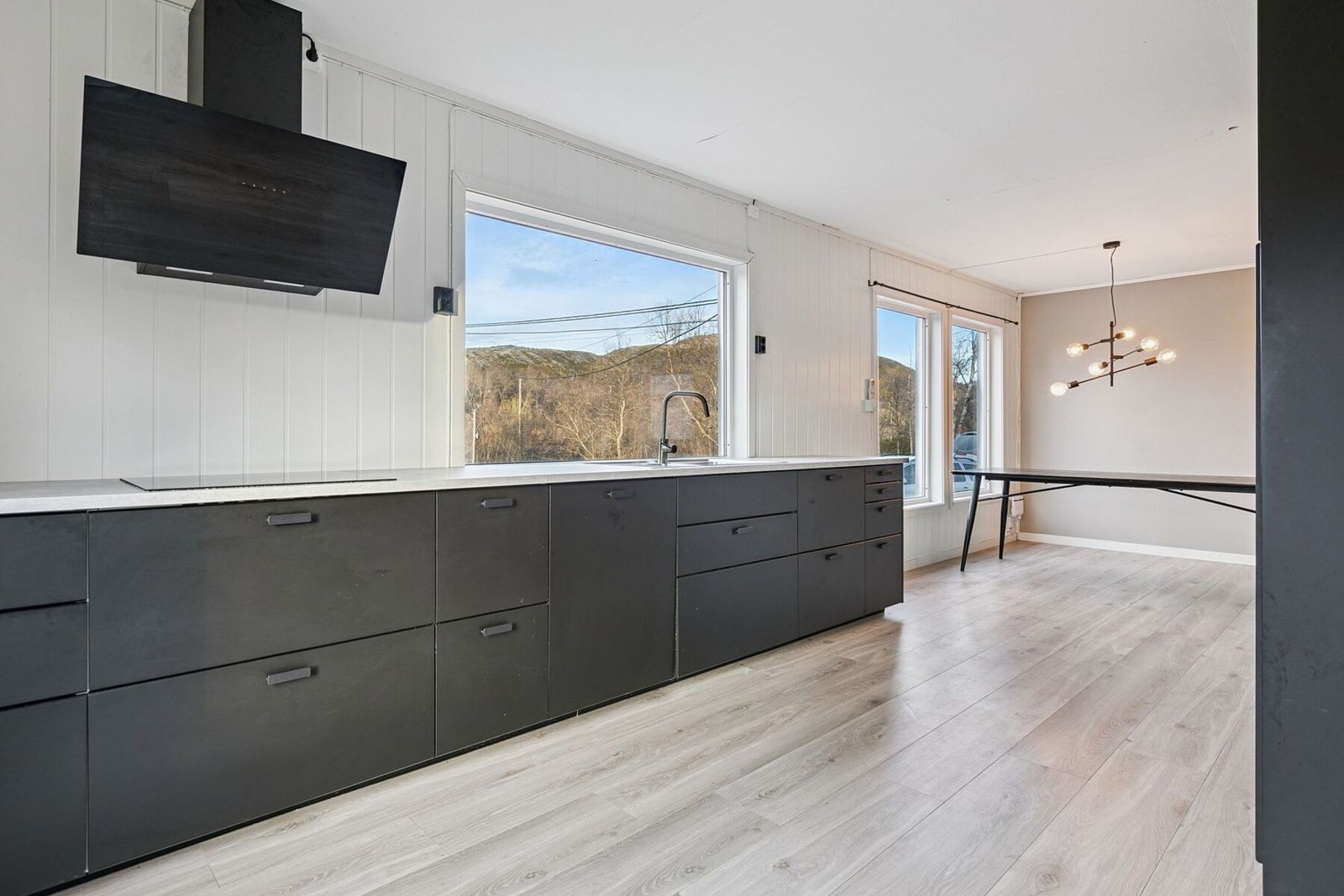 Moderne kjøkkeninnredning med glatte fronter og benkeplate av laminat med god plass til kokkelering Galleribilde