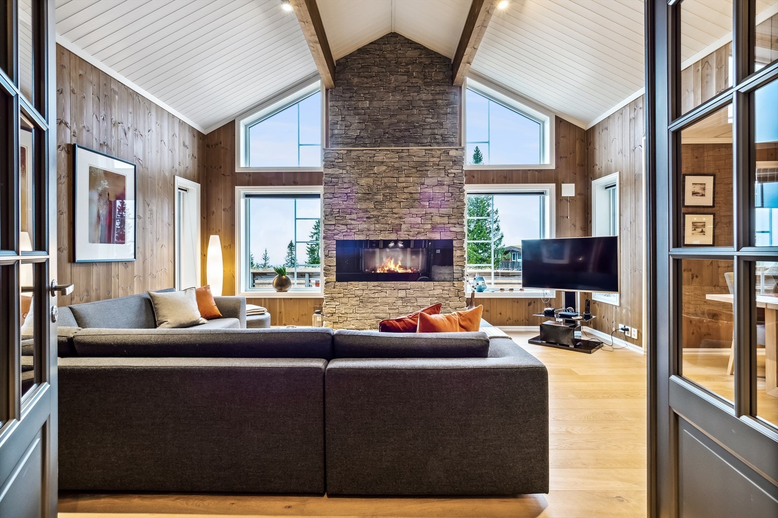 Vi beveger oss inn i stua med en elegant gassovn som midtpunkt Galleribilde