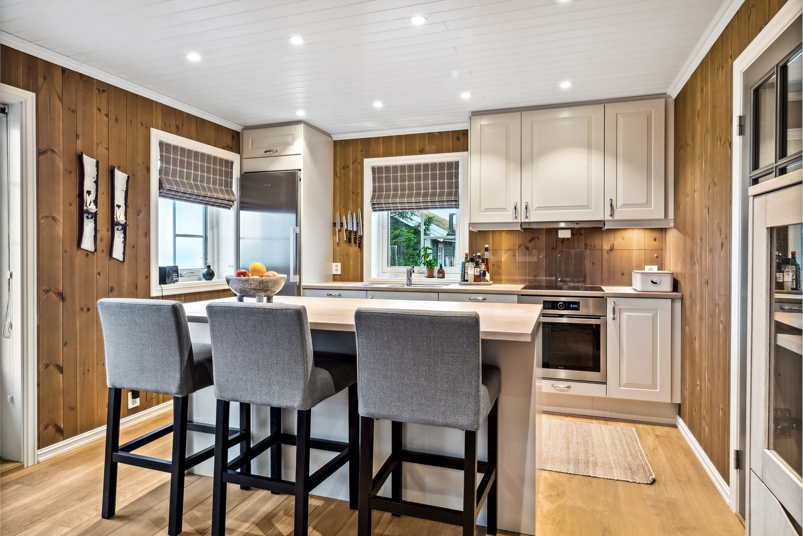 Lyst kjøkken med kjøkkenøy og bar-løsning Galleribilde