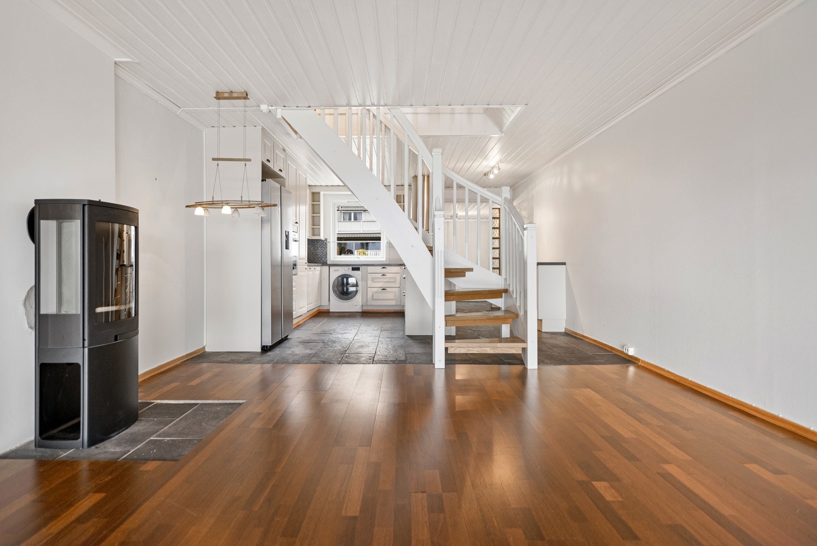 Det er en delvis åpen kjøkkenløsning, der trappen opp til 2. etasje fungerer som et skille. Galleribilde