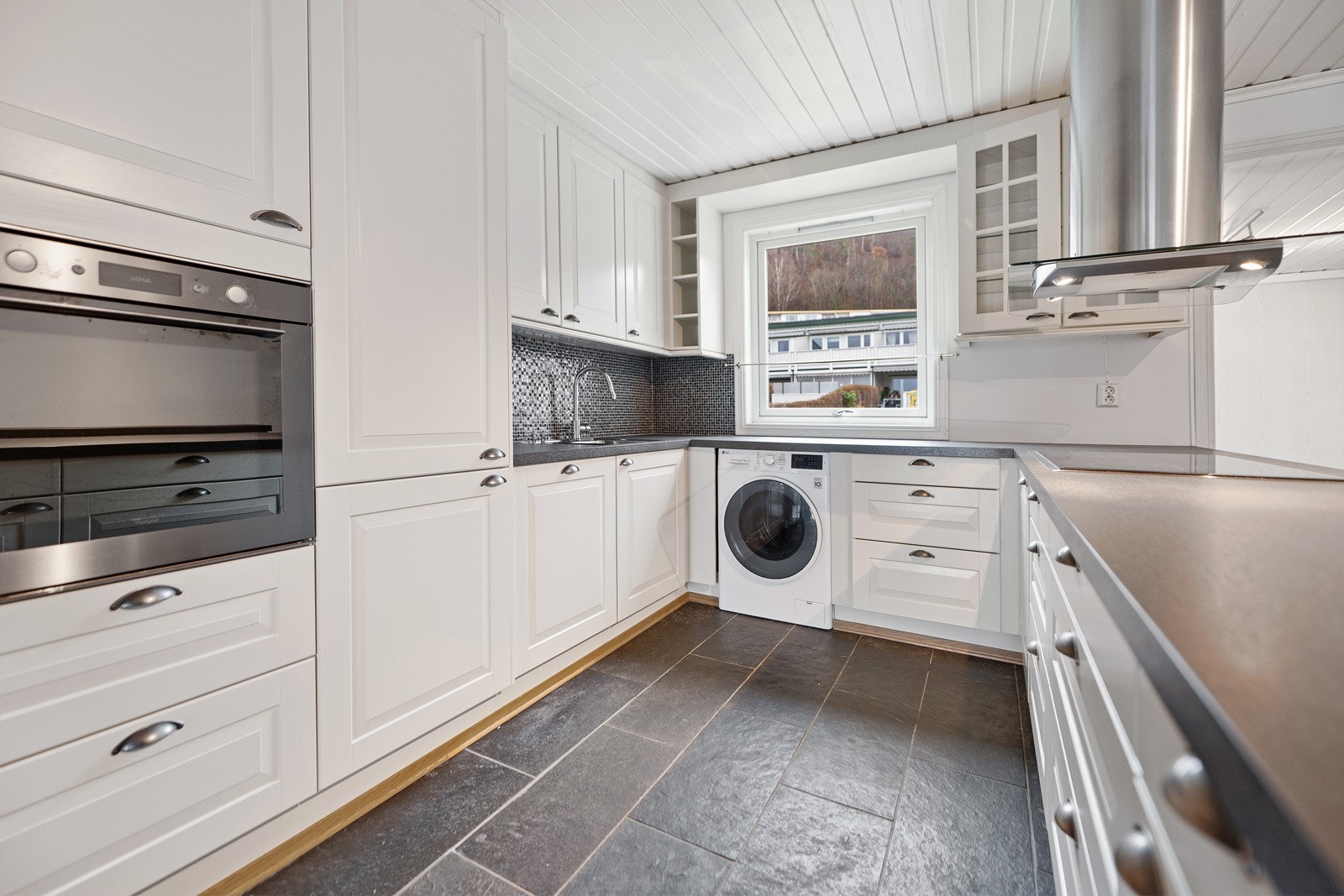 De integrerte hvitevarene består av en komfyr i praktisk arbeidshøyde, oppvaskmaskin og stor induksjonstopp. Det er også et frittstående side-by-side-kjøleskap med vanndispenser. Galleribilde