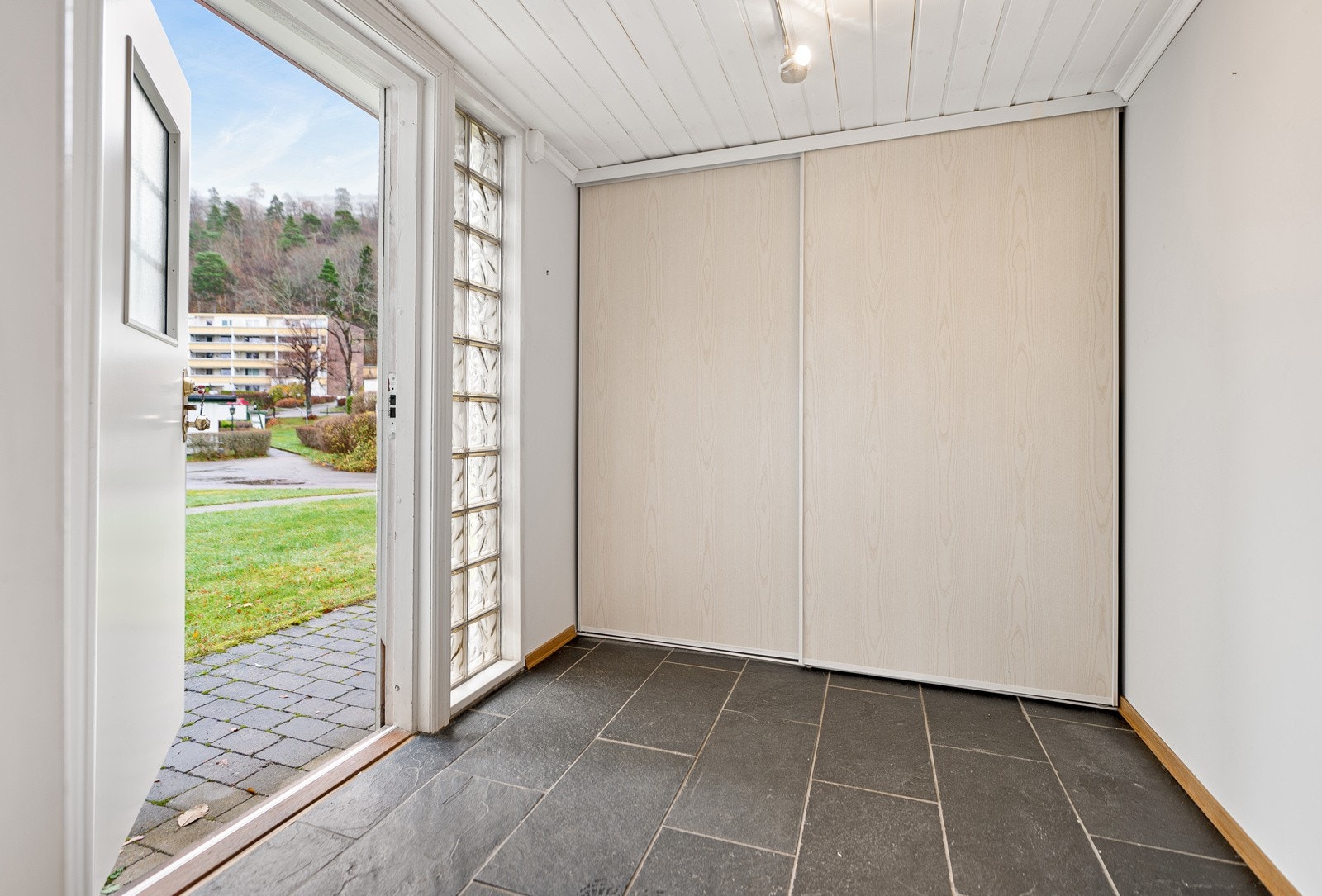 Velkommen inn i pen flislagt gang med skyvedørsgarderobe. Galleribilde