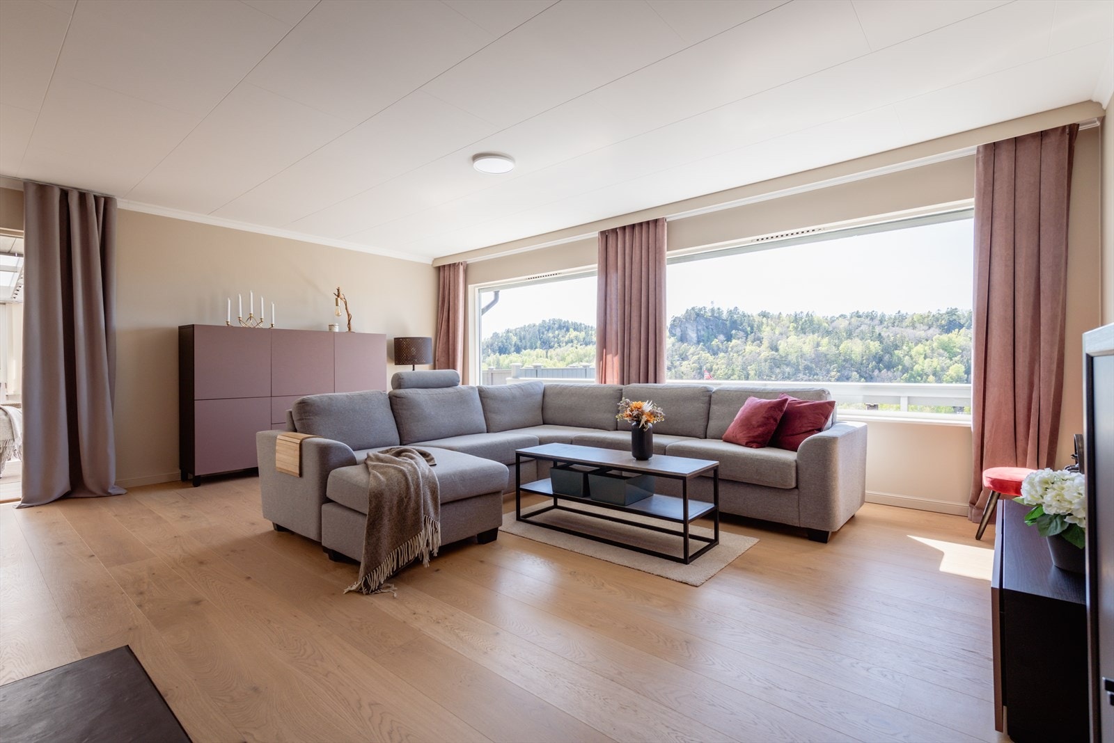 Stor og lys stue, med store vindusflater. Her får man masse naturlig lysinnslipp og man har god utsikt over nærområdet. Galleribilde