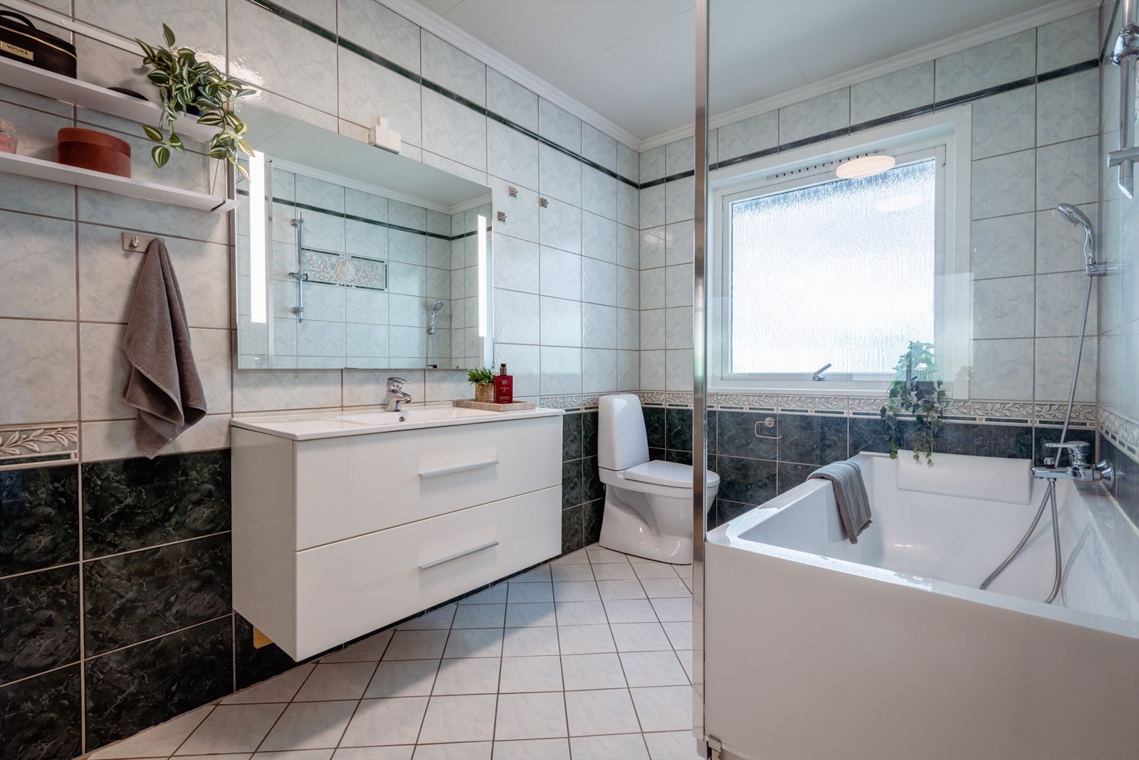 Stort bad, som er innredet med badekar, dusj, wc og servant med innredning i skuffer. Galleribilde