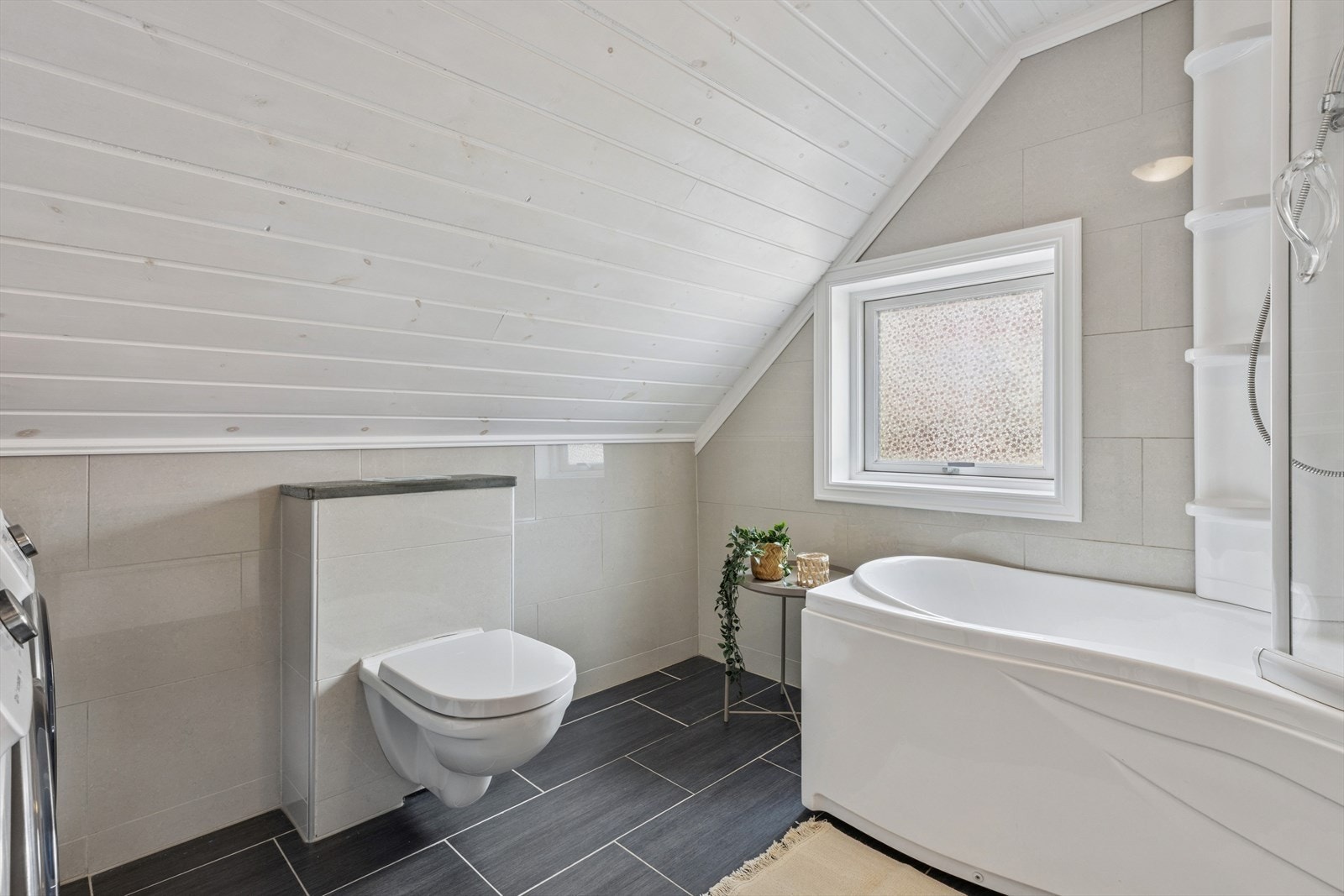 Badet har moderne fargevalg. Dusjkaret gir deg både mulighet til et deilig bad eller en rask dusj, avhengig av hva du har behov for. Galleribilde