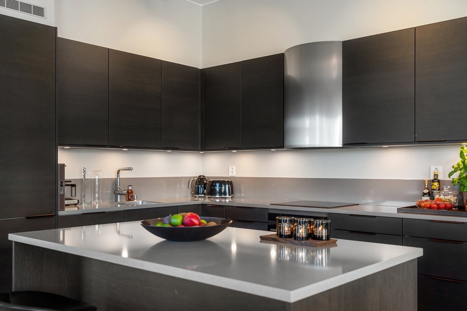 Integrert i kjøkkeninnredningen er induksjonstopp, stekeovn, vinskap, oppvaskmaskin og kjøl/frys. Avtrekksvifte over platetopp. Galleribilde