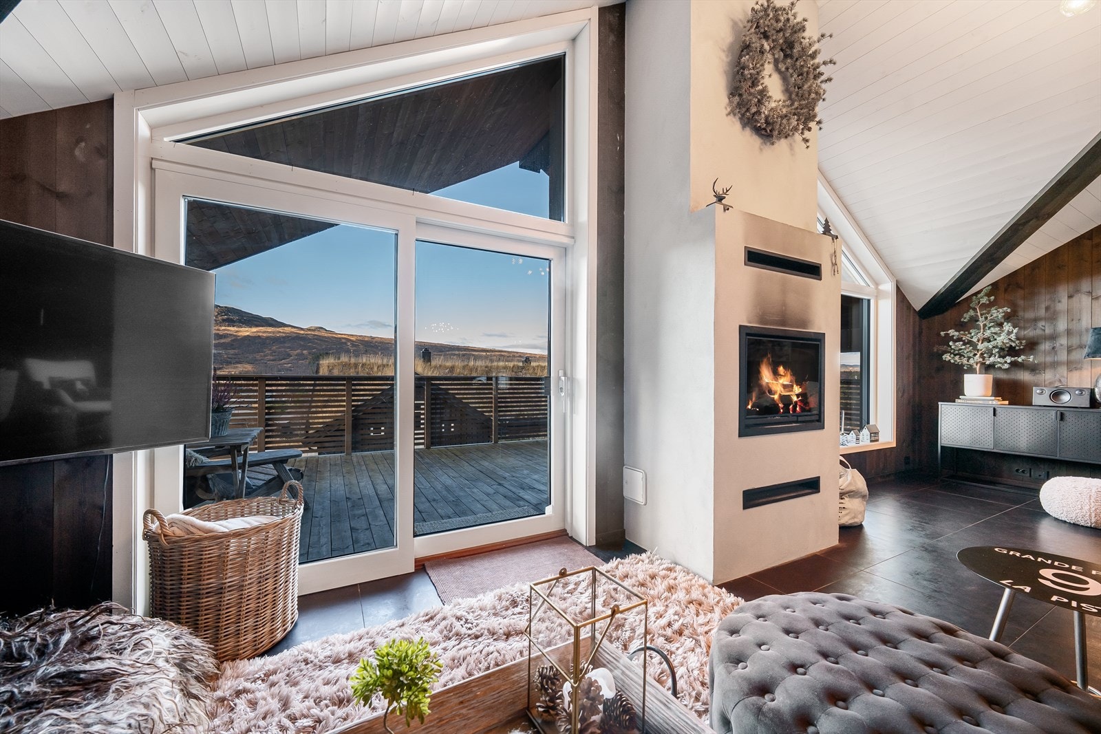 Fra stuen er det utgang til stor veranda med utsikt mot bakken. Galleribilde