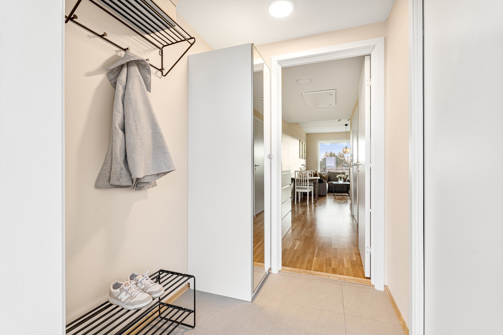 Innbydende og flislagt entré med god plass til oppheng av klær. Galleribilde