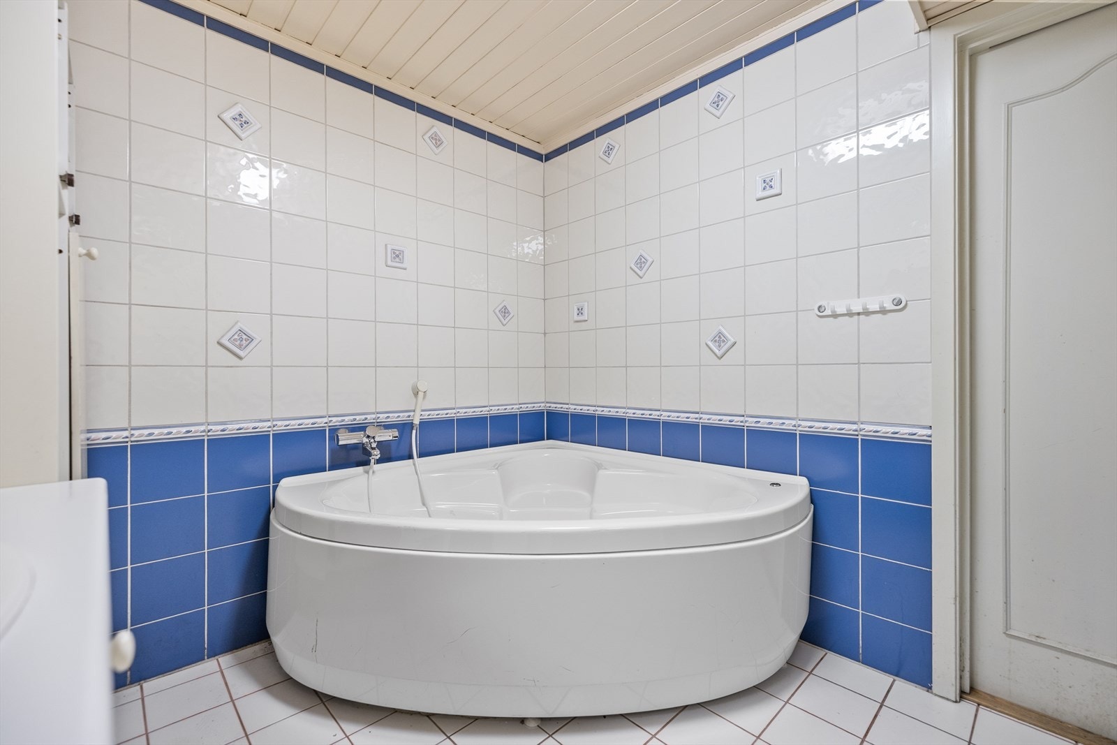 Taket er kledd med malt panel, og rommet er innredet med hjørnebadekar med dyser (ikke funksjonstestet), servantskap, to overskap og et høyskap som gir godt med oppbevaringsplass. Galleribilde