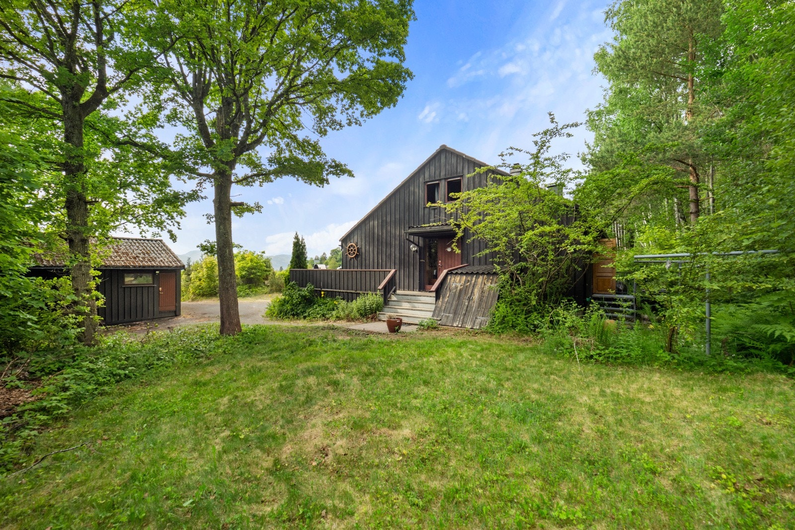 Tomten er opparbeidet med singlet oppkjørsel, naturtomt, plenarealer og diverse beplantning Galleribilde