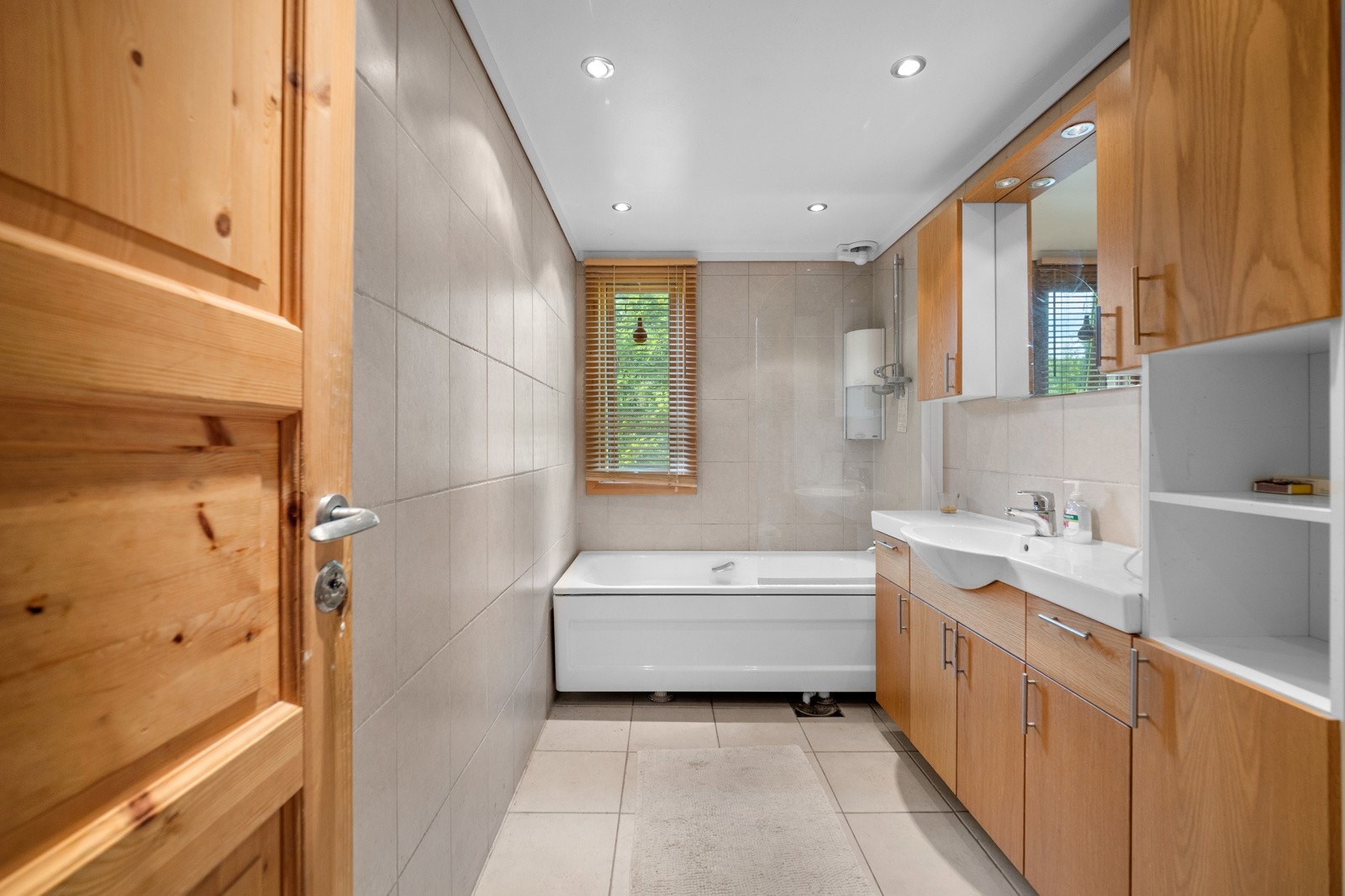 Badet er flislagt med varme i gulvet - Himling med downlights Galleribilde