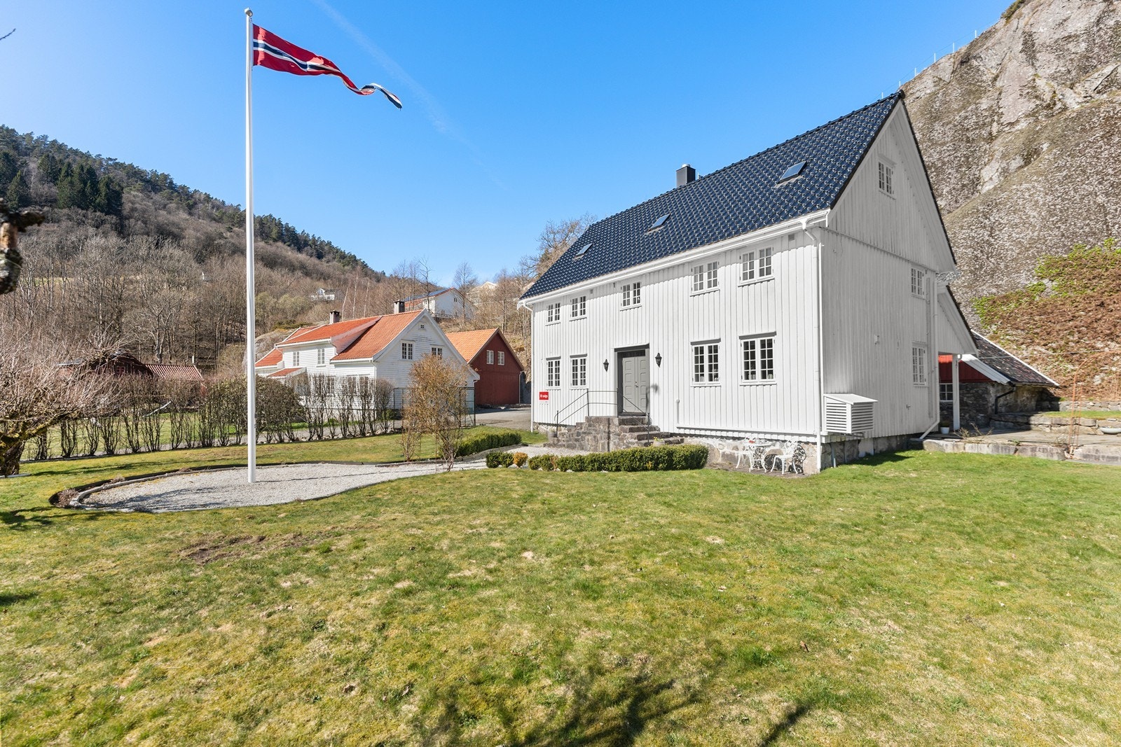 Gjennomført eiendom med grusgang og flaggstang. Galleribilde