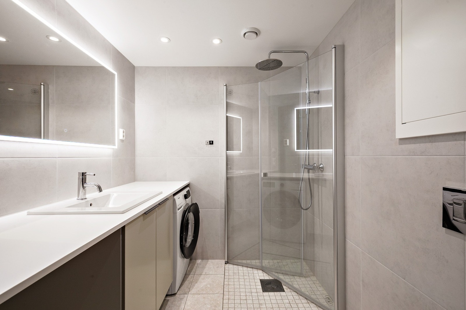 Lekkert bad med vaskemaskin som også medfølger handelen. Den store benkeplata gir et ryddig uttrykk og har rom for for eksempel skittentøyskurg under Galleribilde