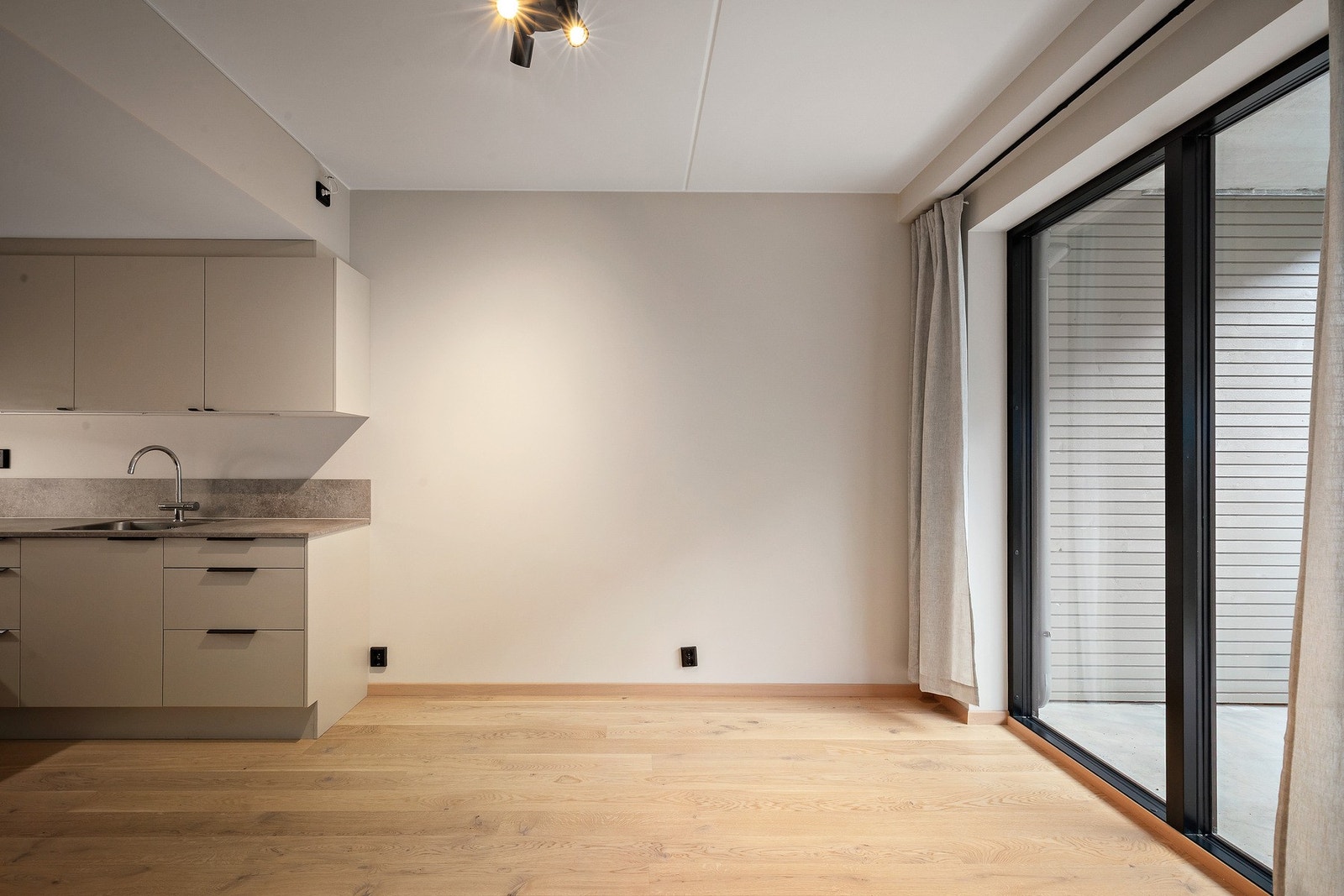 Den åpne stue-/kjøkkenløsningen er på 19,4 kvm og har plass til å innrede med sofa, TV og et spisebord Galleribilde