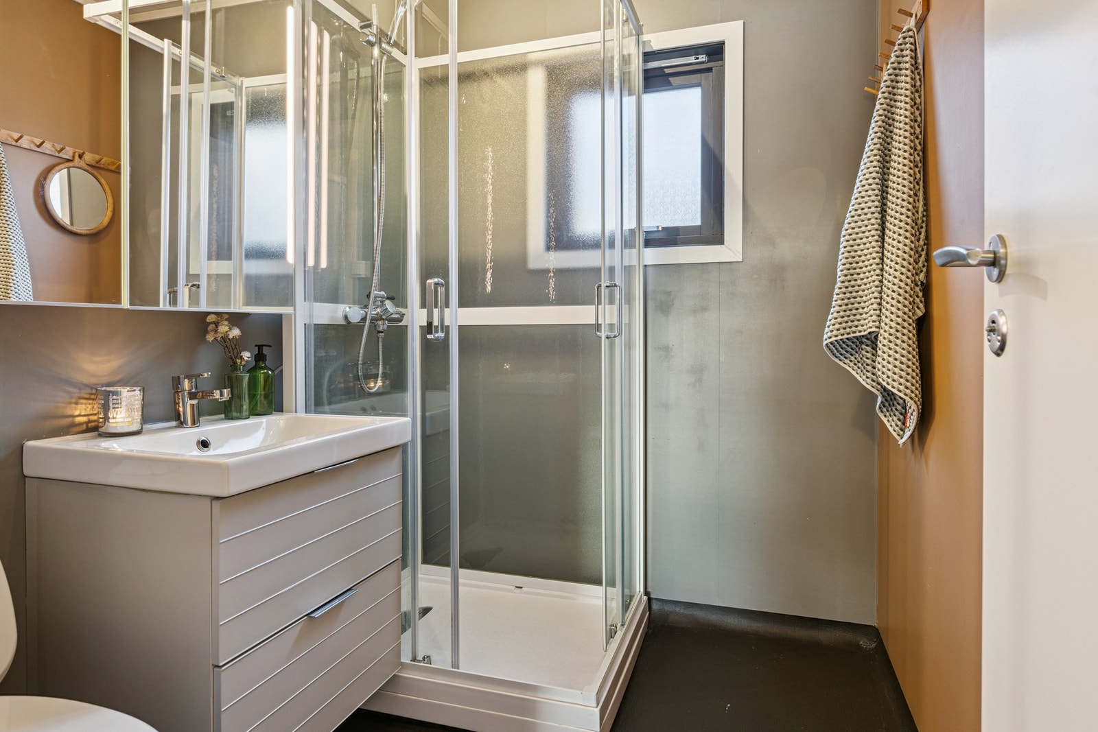 Bad med innredning, dusjkabinett og toalett. Galleribilde