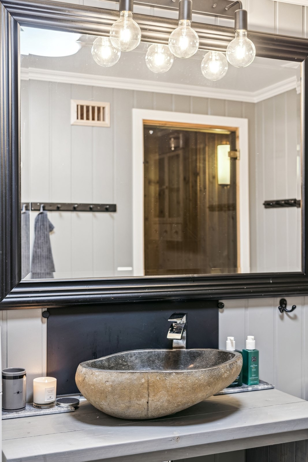 Badet har servantbenk med hyller, delikat toppmontert servant med ettgreps armatur og speil med belysning. Galleribilde