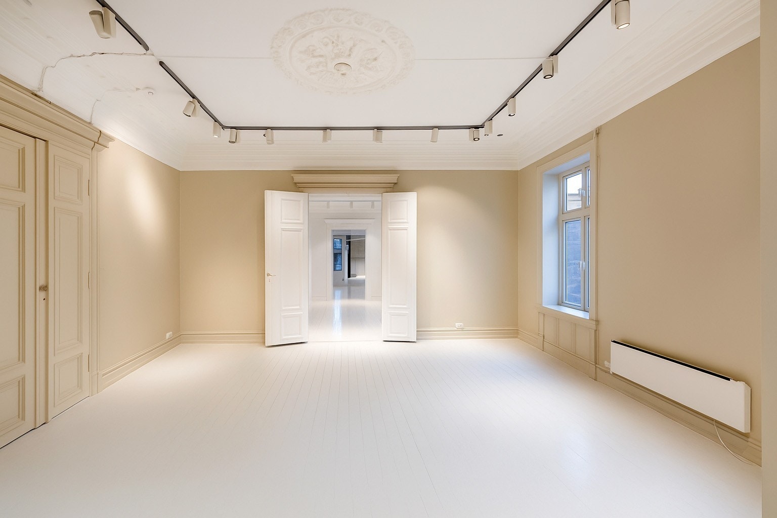 Flotte store rom med originale doble dører. Illustrasjon av lokalene med malt gulv. Galleribilde