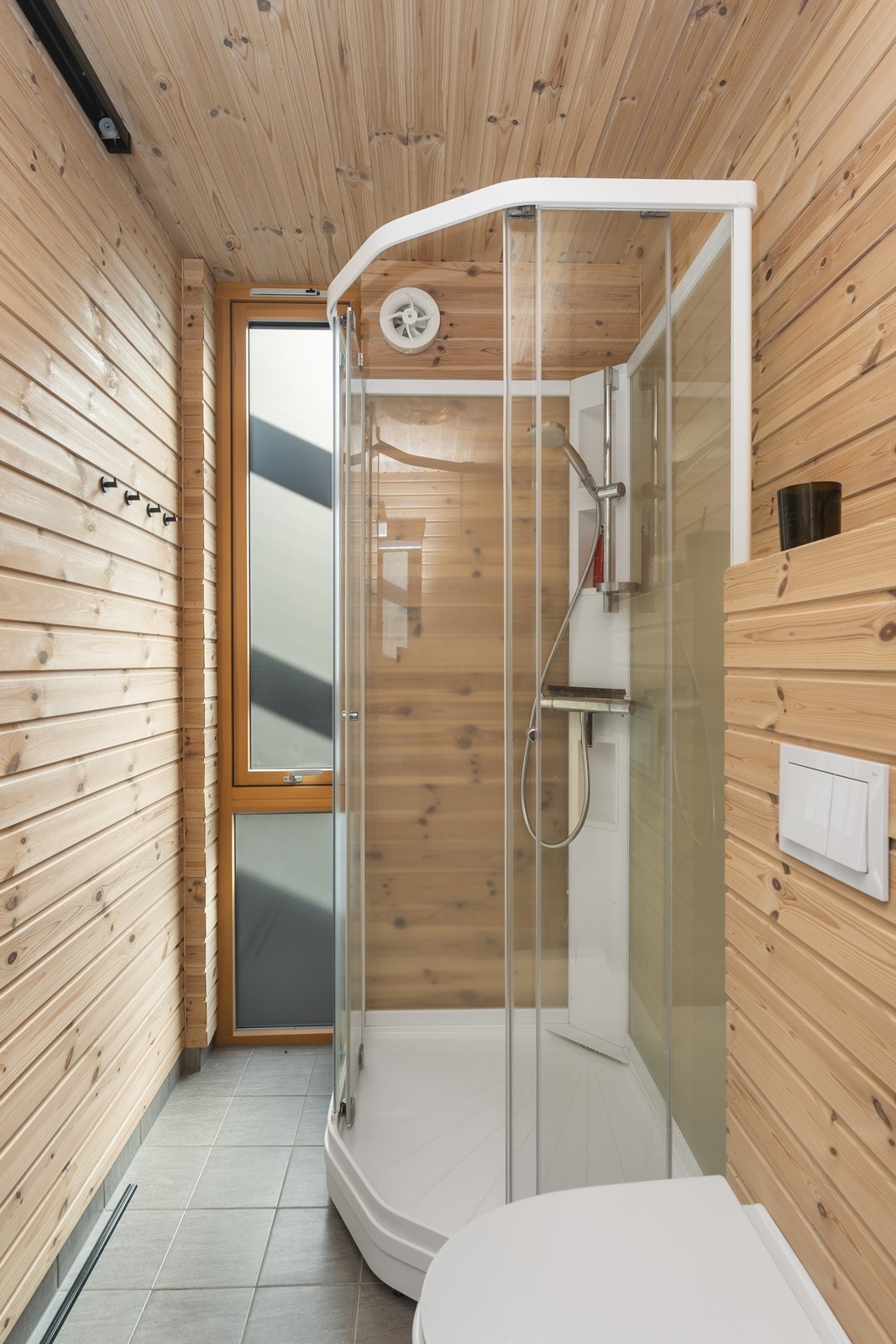 Det er innredet med dusjkabinett, vegghengt wc, servant og skyvedør med hyller til oppbevaring Galleribilde