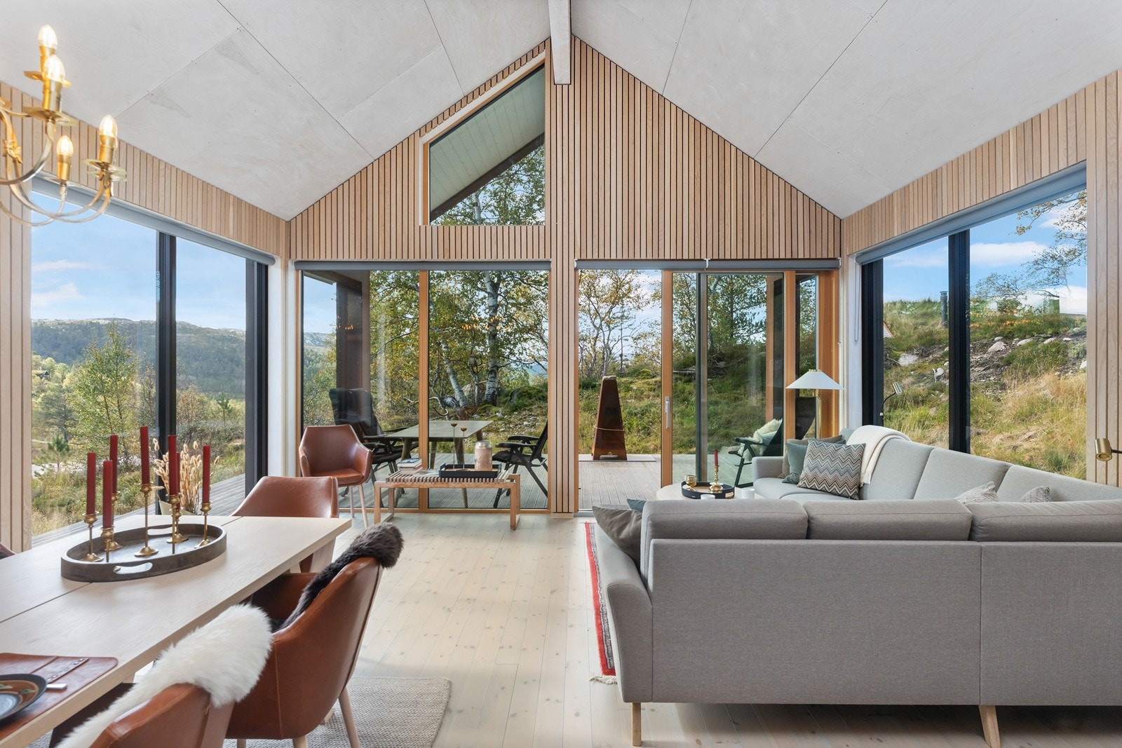 Kombinasjonen av trepanel og store vinduer gir en lun og stilren atmosfære. Galleribilde