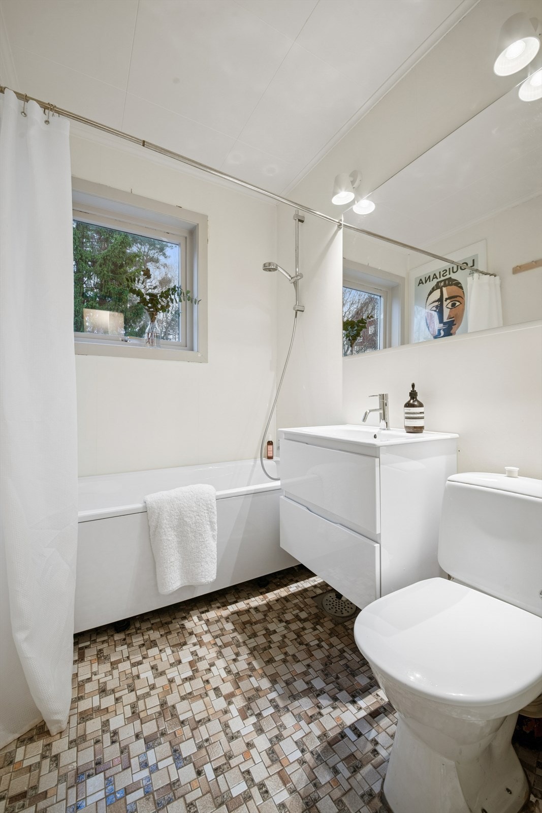 Bad med fliser på gulv og plater på vegger. Rommet har servant, toalett og badekar. Oppgradert med ny servant med underskap og badekar. Teknisk/fukt teknisk er badet fra byggeåret. Våtrommet må oppgraderes for å tåle normal bruk etter dagens krav. Galleribilde