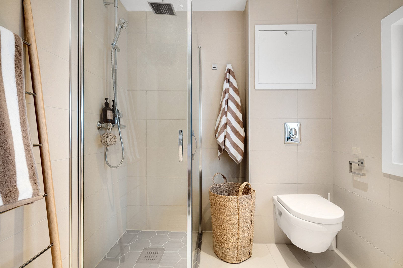 Utstyrt med dusjhjørne med hånd- og takdusj/regnfallsdusj, innfellbare glassdører, servant med skuffeskap og vegghengt toalett. Galleribilde