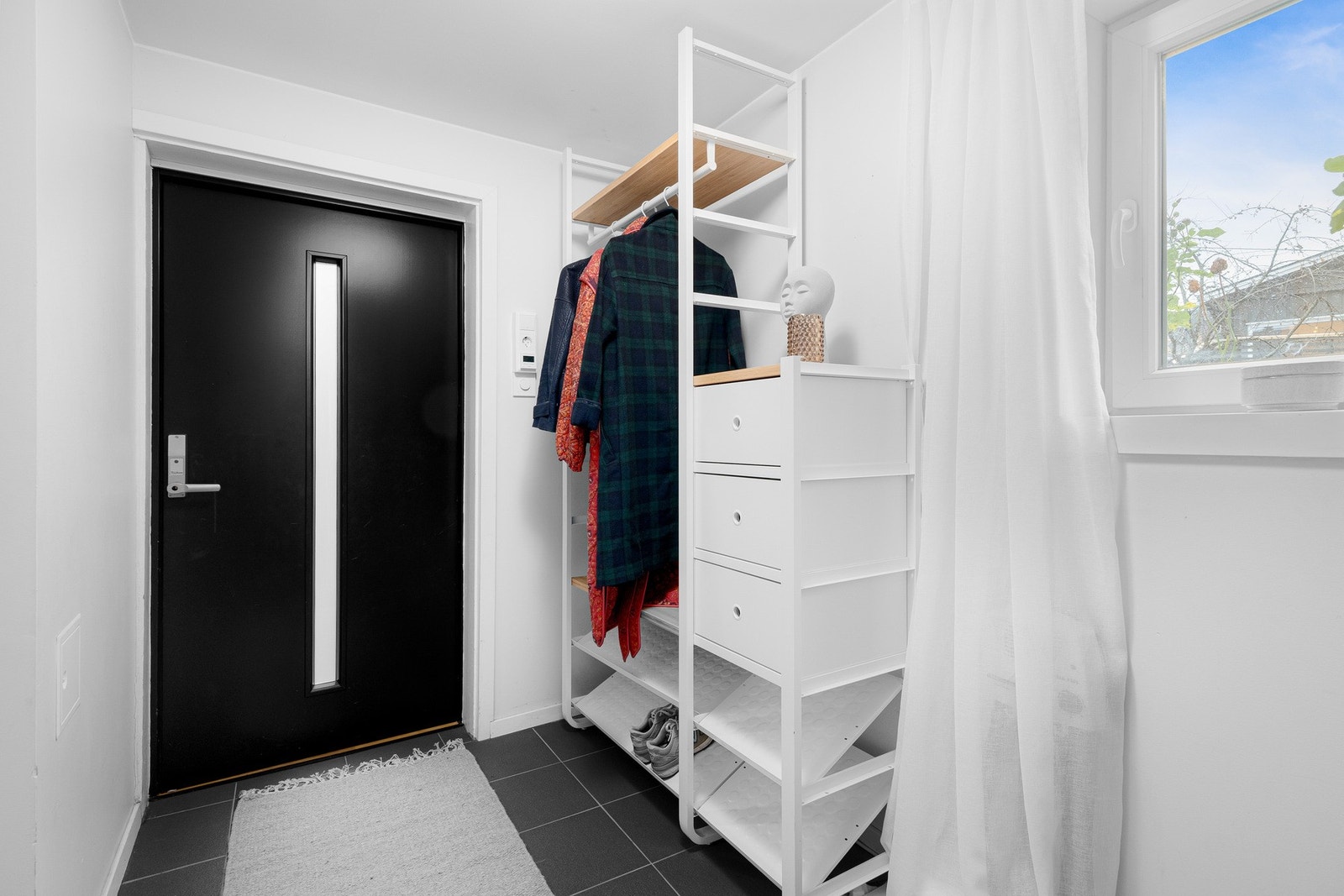 Velkommen inn i en innbydende og praktisk entré med plass til å sette fra seg sko og henge yttertøy rett innenfor døren. Galleribilde