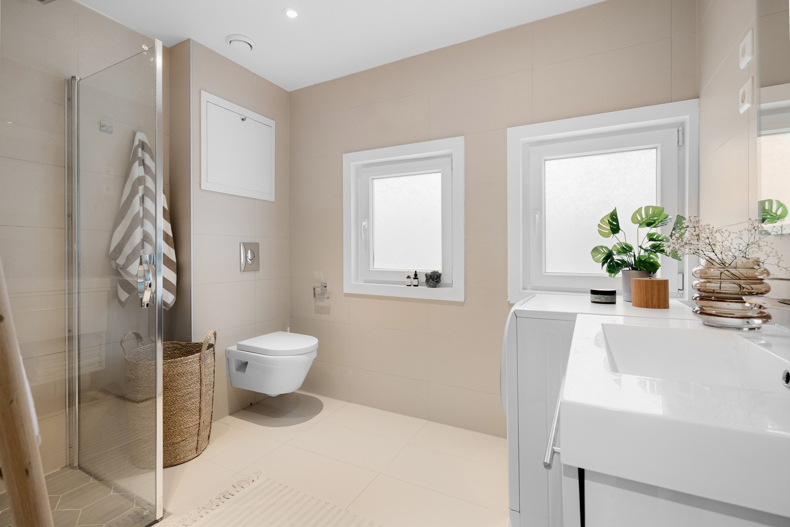 Badet har fliser på både gulv og vegger, med ekstra påkostet fliser i dusjsonen. Galleribilde