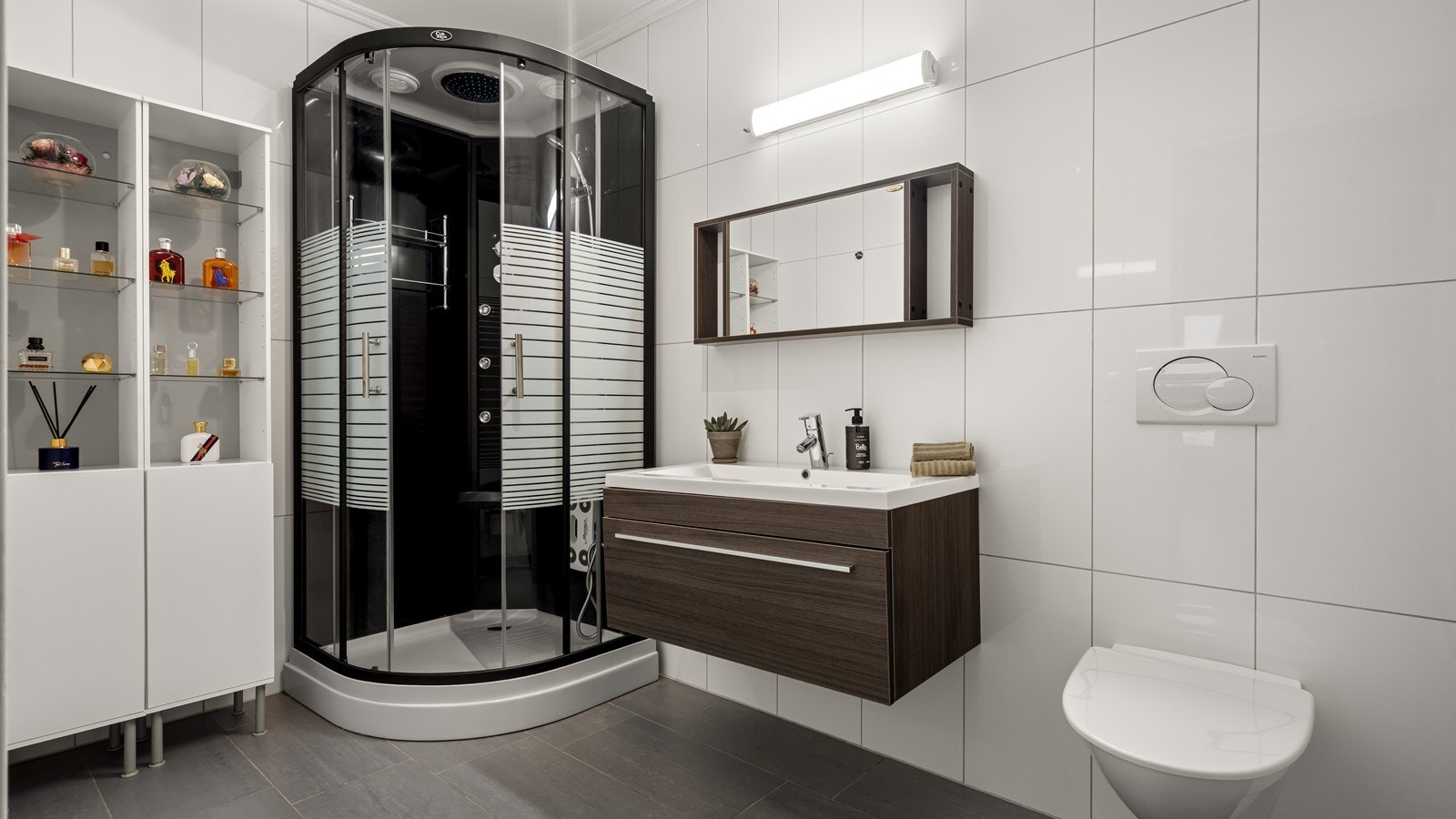 Bad i 1.etg. med flis på gulv - varmekabler - dusjkabinett og vegghengt wc Galleribilde