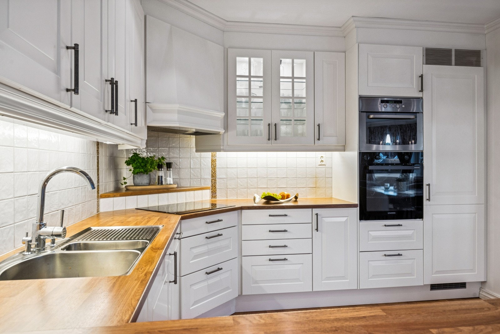 Delikat kjøkken med lyse fronter, integrerte hvitevarer og benkeplater. Galleribilde