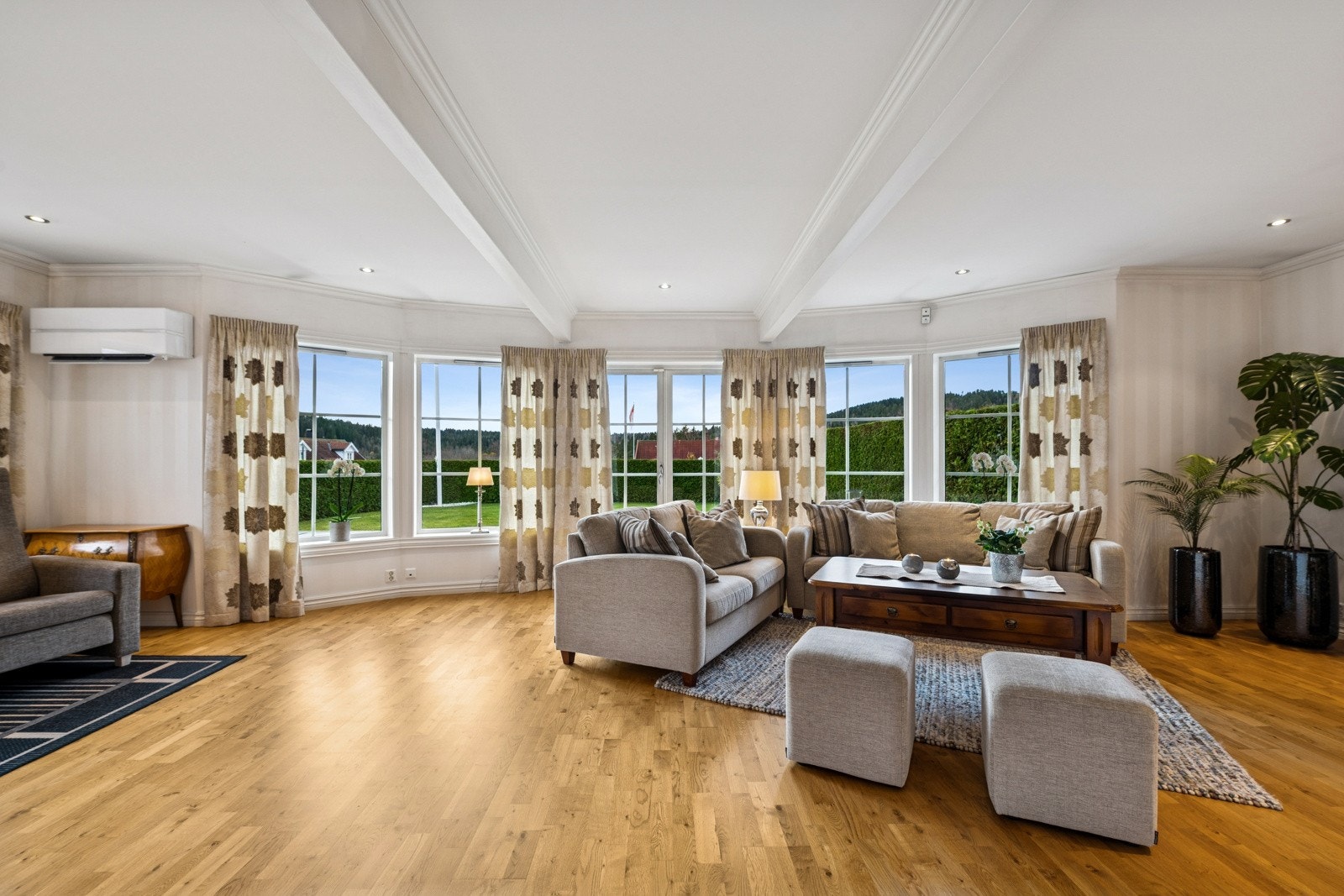 Lys og innbydende stue med store vindusflater som slipper inn rikelig med naturlig lys. Galleribilde