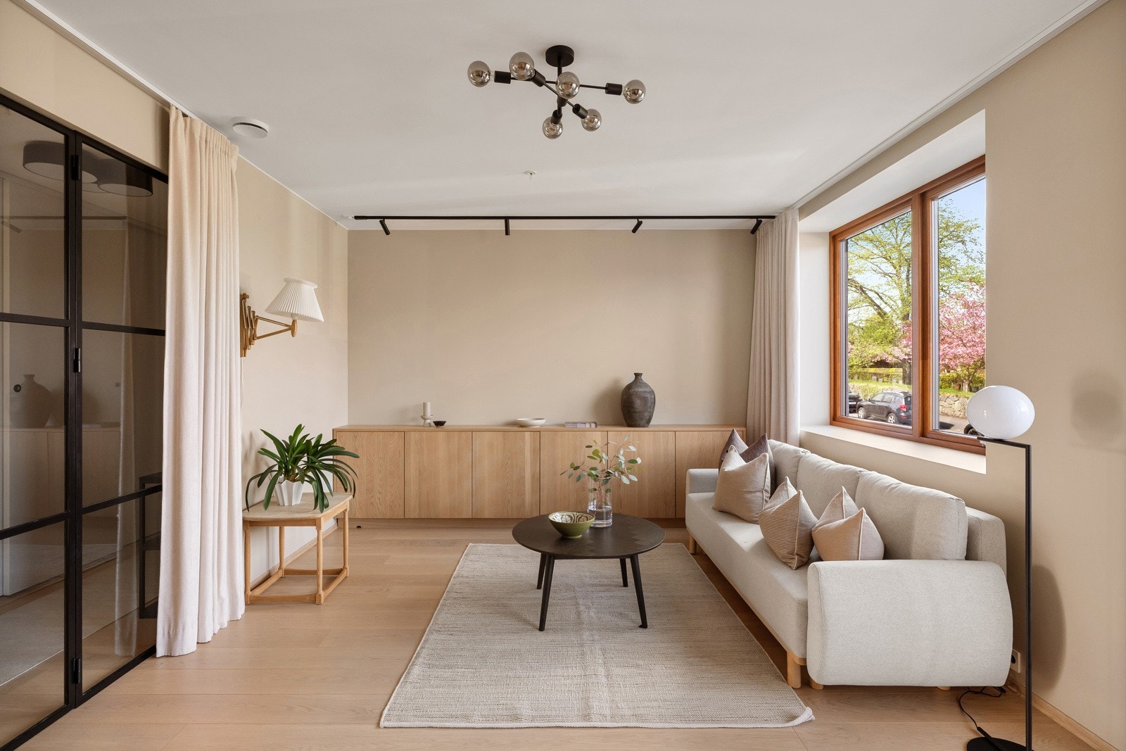 Vinduene gir godt dagslys og har dyp, listefri karm med plass til pynt. Stuen har listefri, hvitmalt himling, flott takhøyde, glatte, beige veggflater, mørk fondvegg og enstavs parkettgulv. Galleribilde