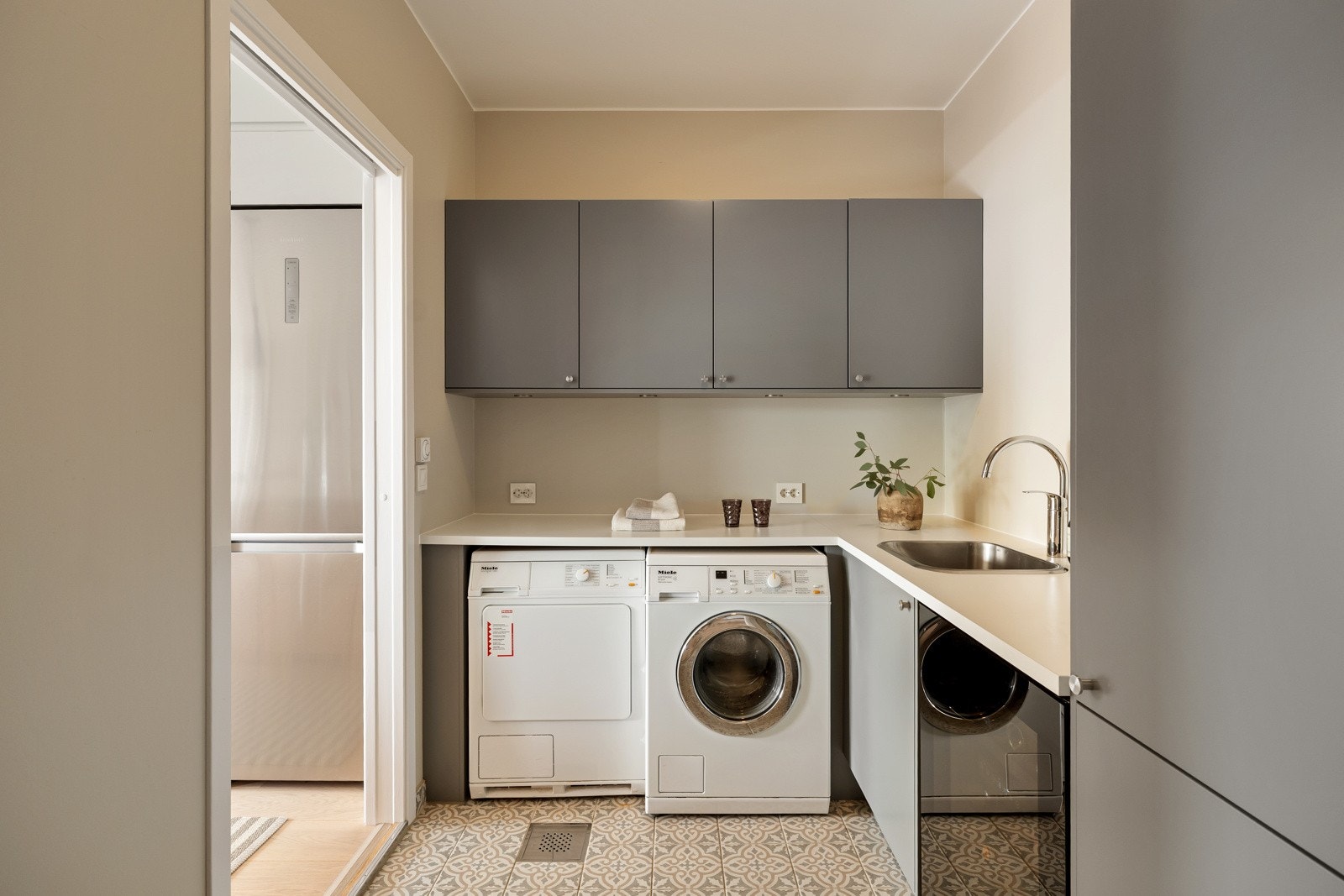 Vaskerommet som også blir brukt som grovkjøkken og matbod, ligger smart plassert med adkomst via skyvedør både fra kjøkkenet og entreen. Galleribilde