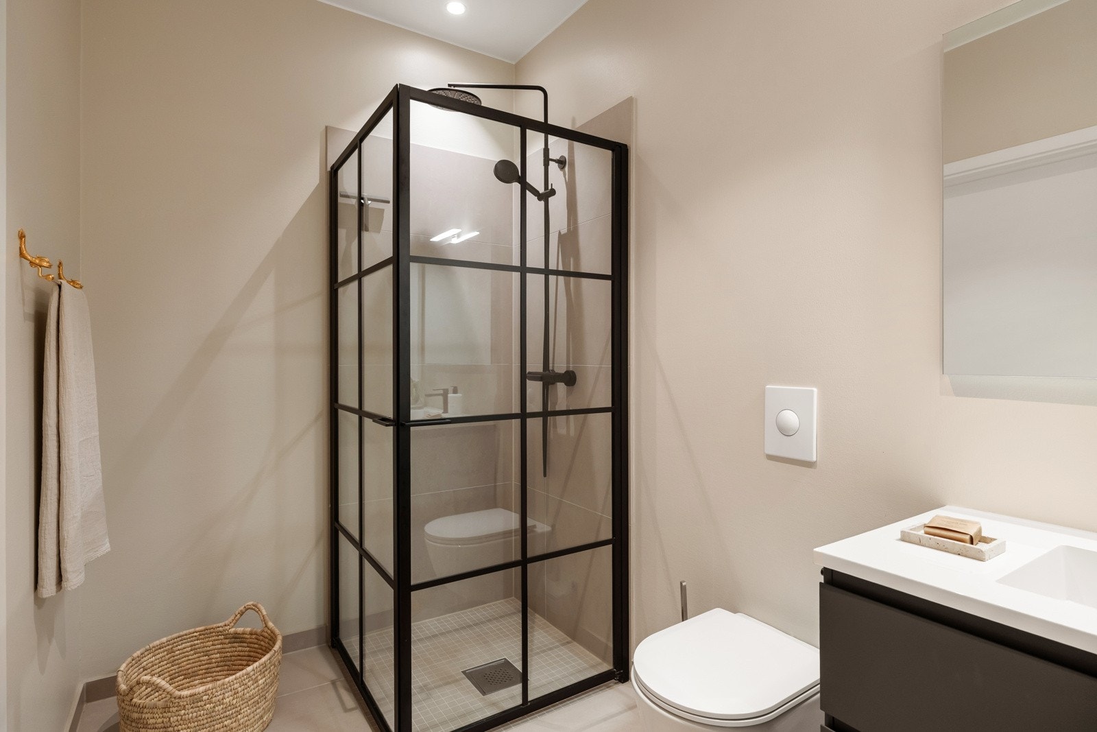 Innredningen består av en heldekkende servant på sort skuffeseksjon, speil med overlys og et veggmontert toalett. Galleribilde