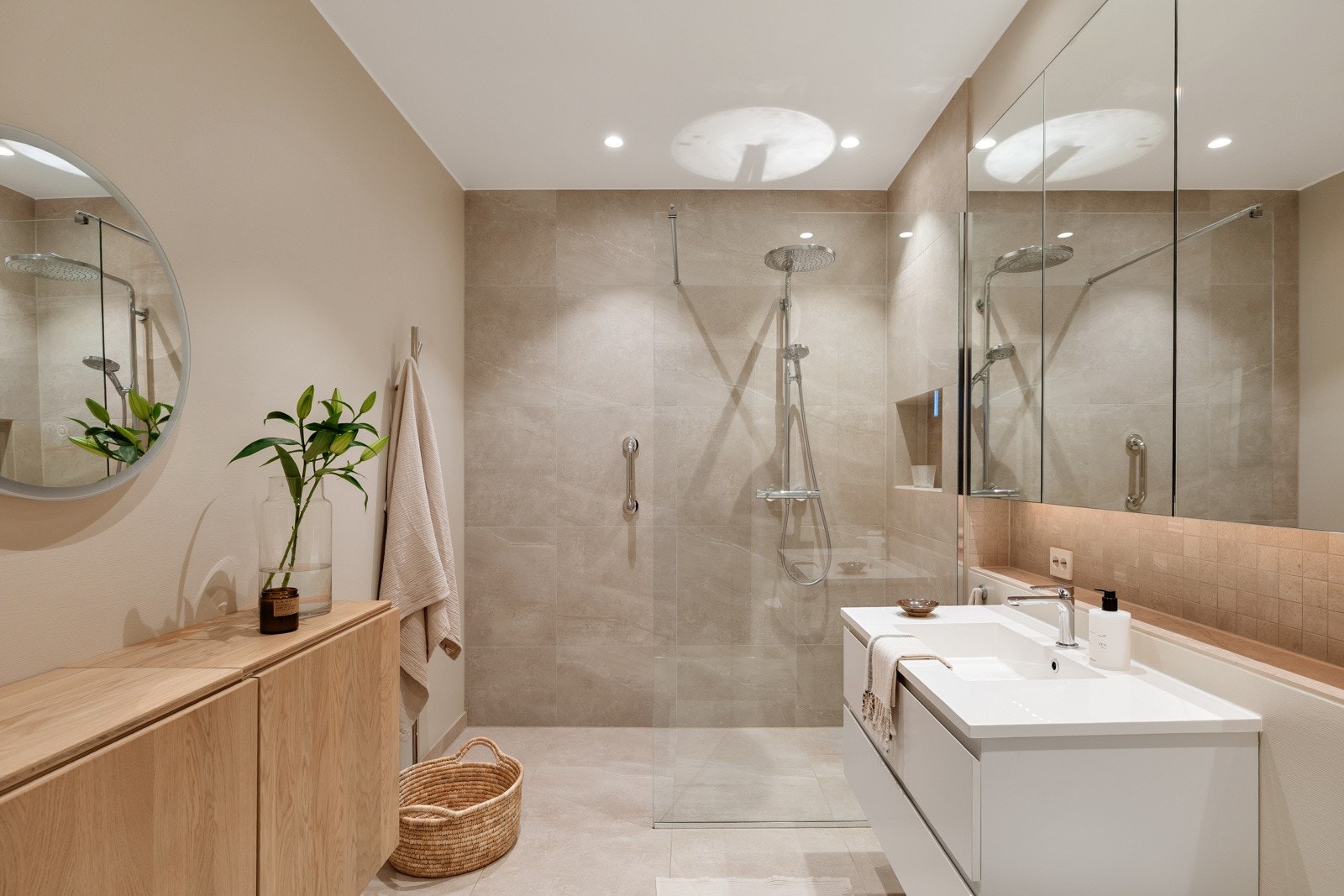 Badet har beige fliser på gulvet, på endeveggen og i hele dusjhjørnet. Galleribilde