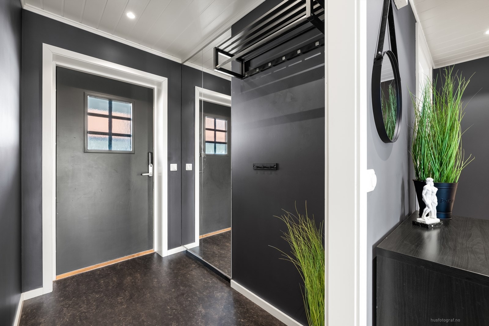 Velkommen inn til en romslig entré med belegg på gulv. Det er god plass til oppheng for yttertøy og til å sette ifra seg sko. Ytterdøren har en praktisk kodelås. Galleribilde