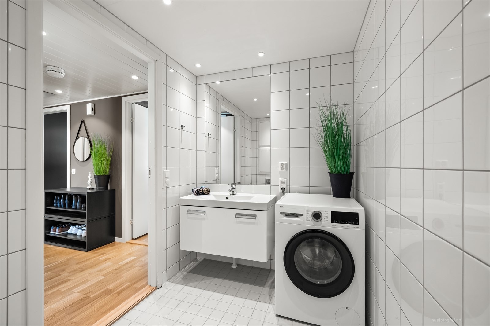 Lyst flislagt bad i 2.etasje med gulvvarme og downlights i tak. Baderomsinnredningen er hvit med heldekkende nedfelt servant med rom for oppbevaring i skuffeseksjon og speil. Galleribilde