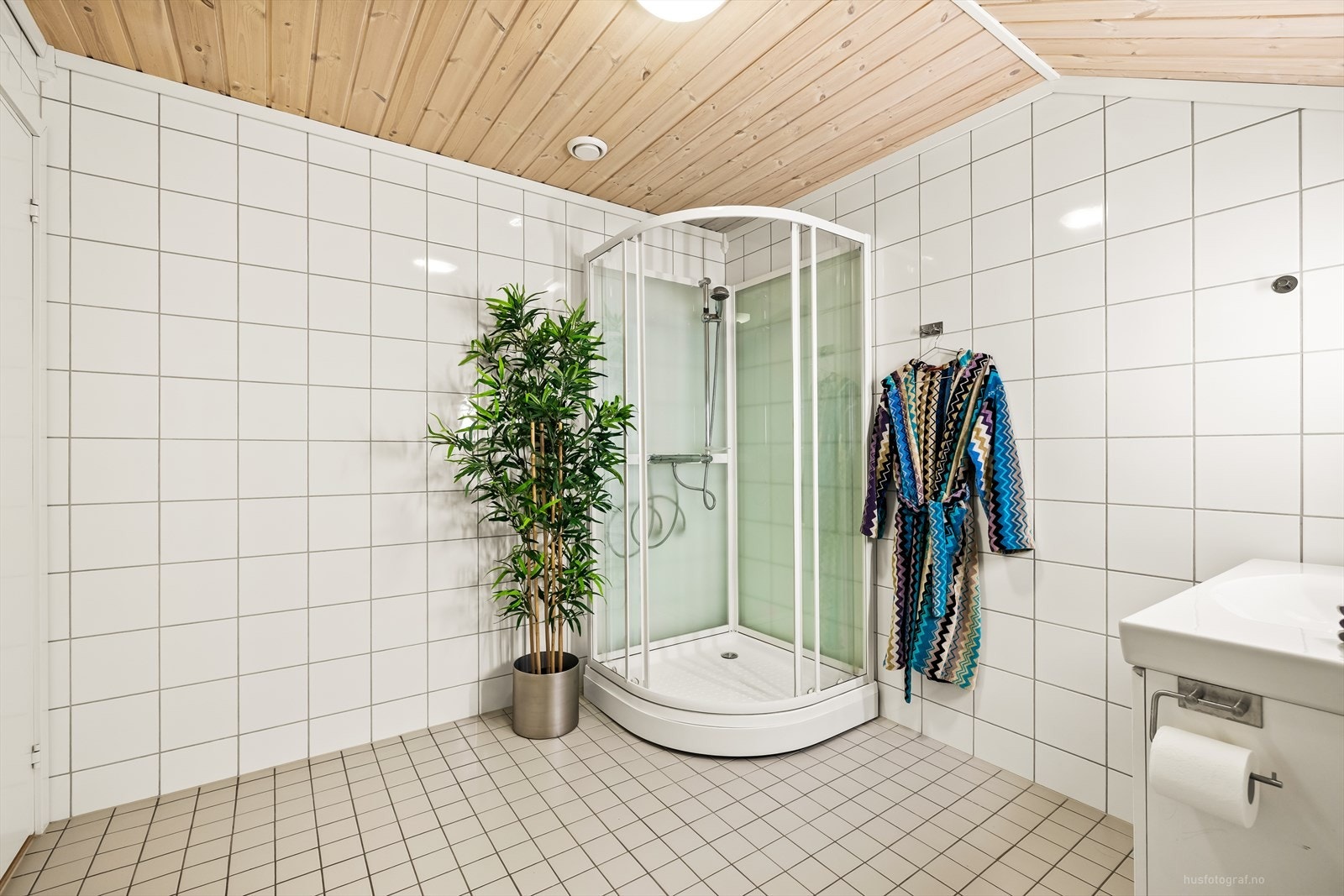 Badet utstyrt med baderomsinnredning med heldekkende servant, speil med belysning, toalett og dusjkabinett. Galleribilde