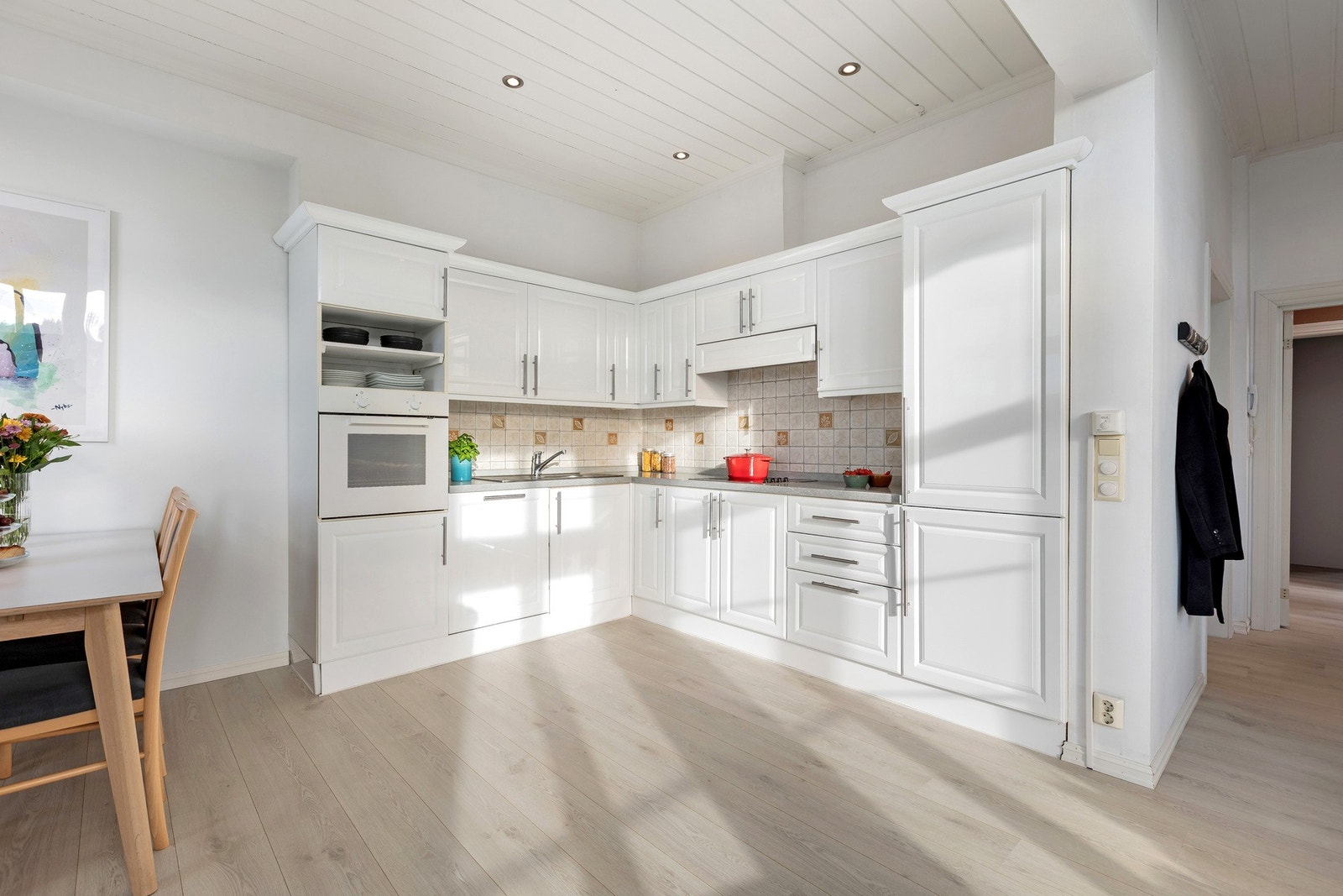 Tidløs innredning med hvite fronter, integrerte hvitevarer og god arbeidsplass. Galleribilde