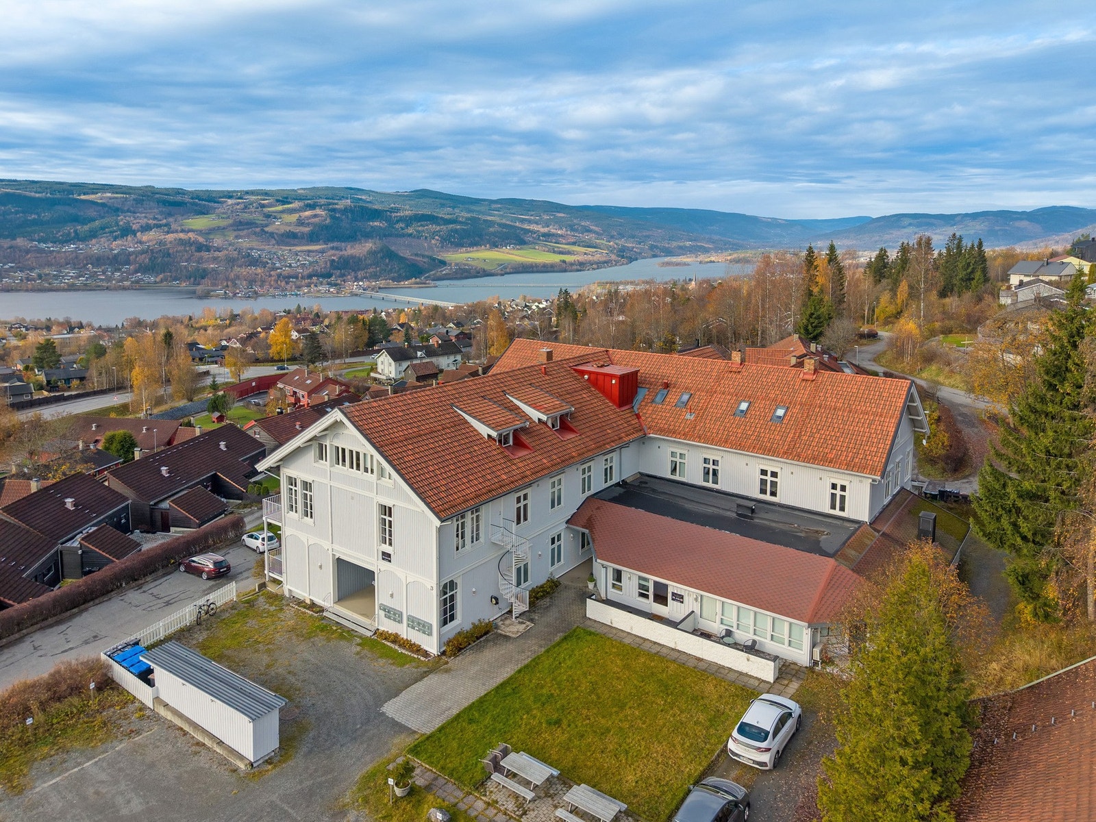 Flott beliggenhet med utsikt mot Mjøsa - Oversiktsbilde som viser bygget og fellesområdet, med kort vei til marka og turstier rett utenfor døren. Galleribilde