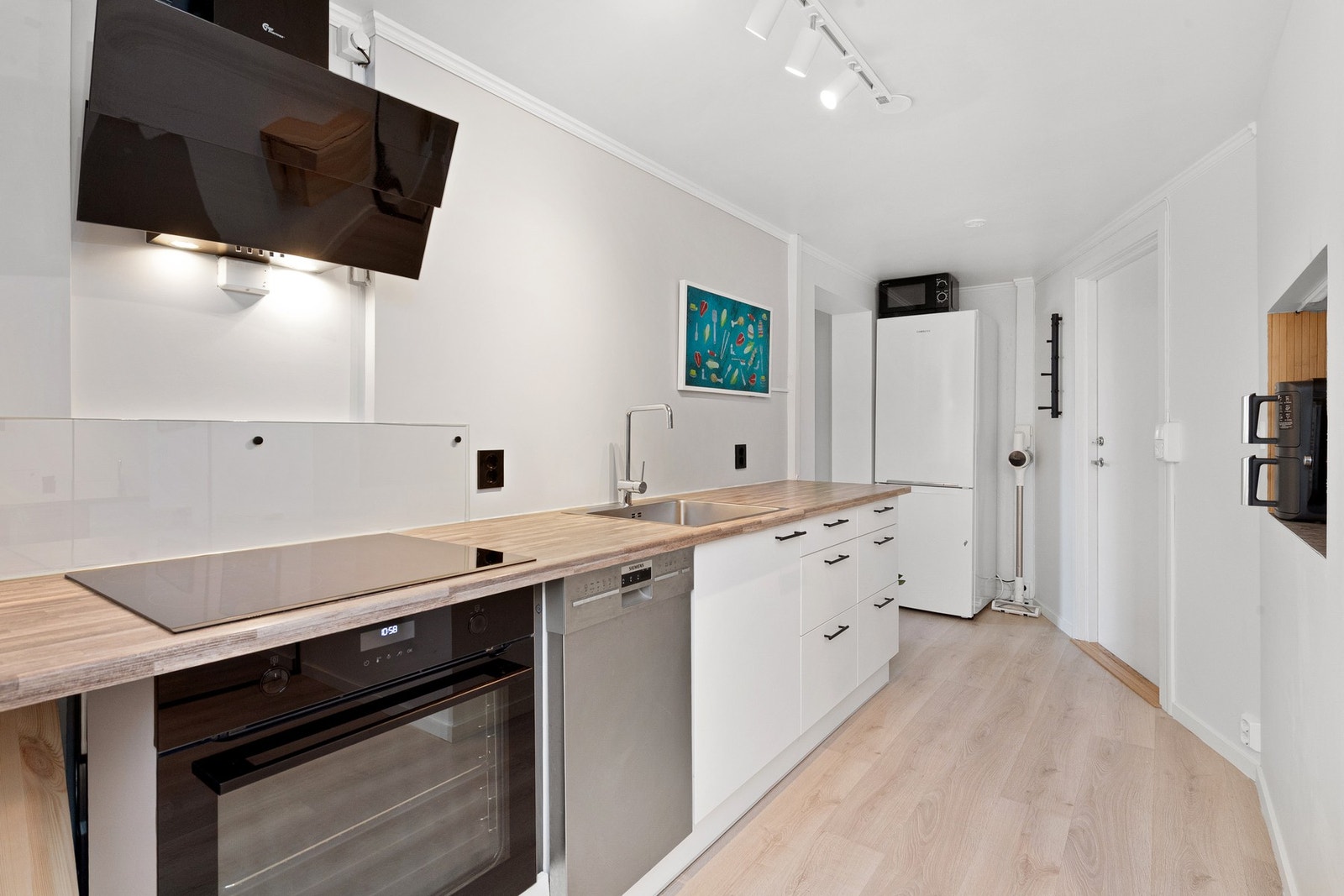 Det er et godt utrustet kjøkken med integrert stekeovn og frittstående vaskemaskin og kombiskap Galleribilde