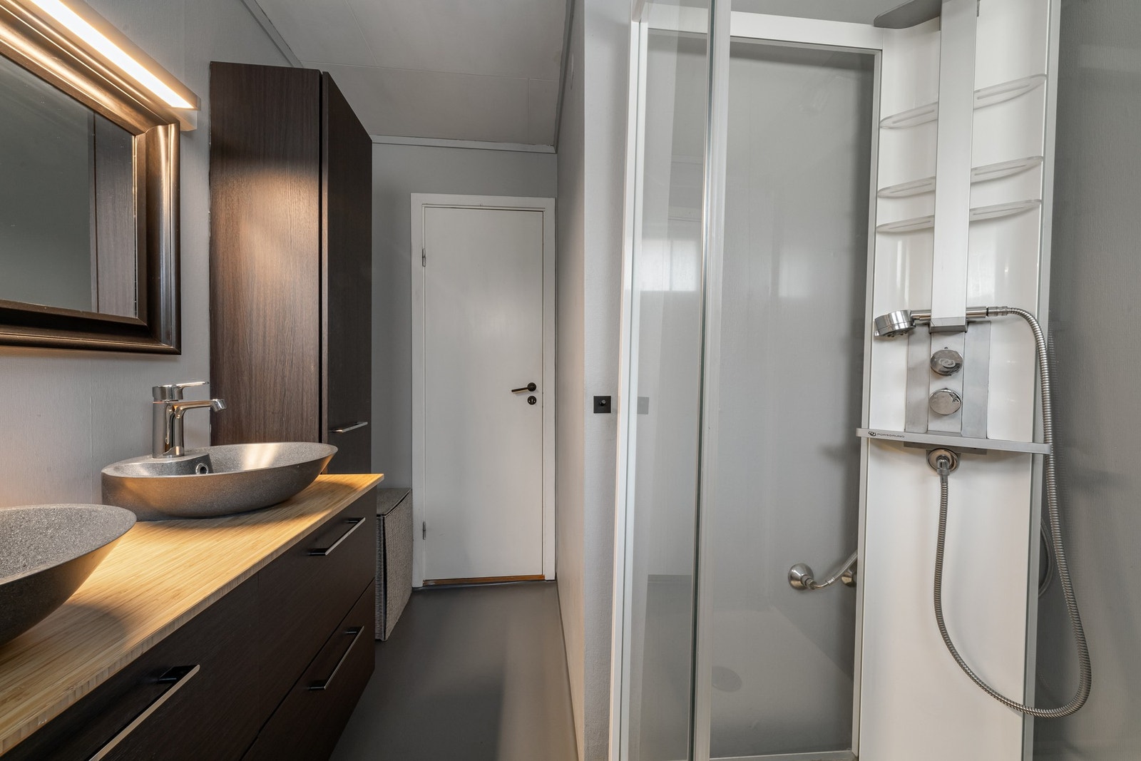 Badet i hovedetasjen med dusjhjørne, toalett og dobbel servant. Galleribilde