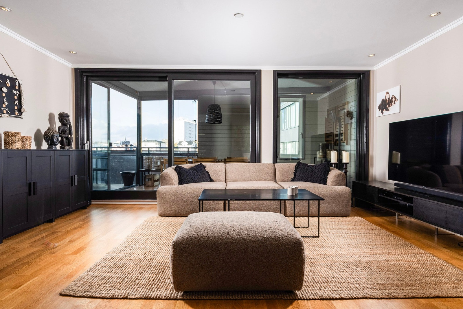 Romslig stue med store vinduer og utgang til innglasset balkong Galleribilde