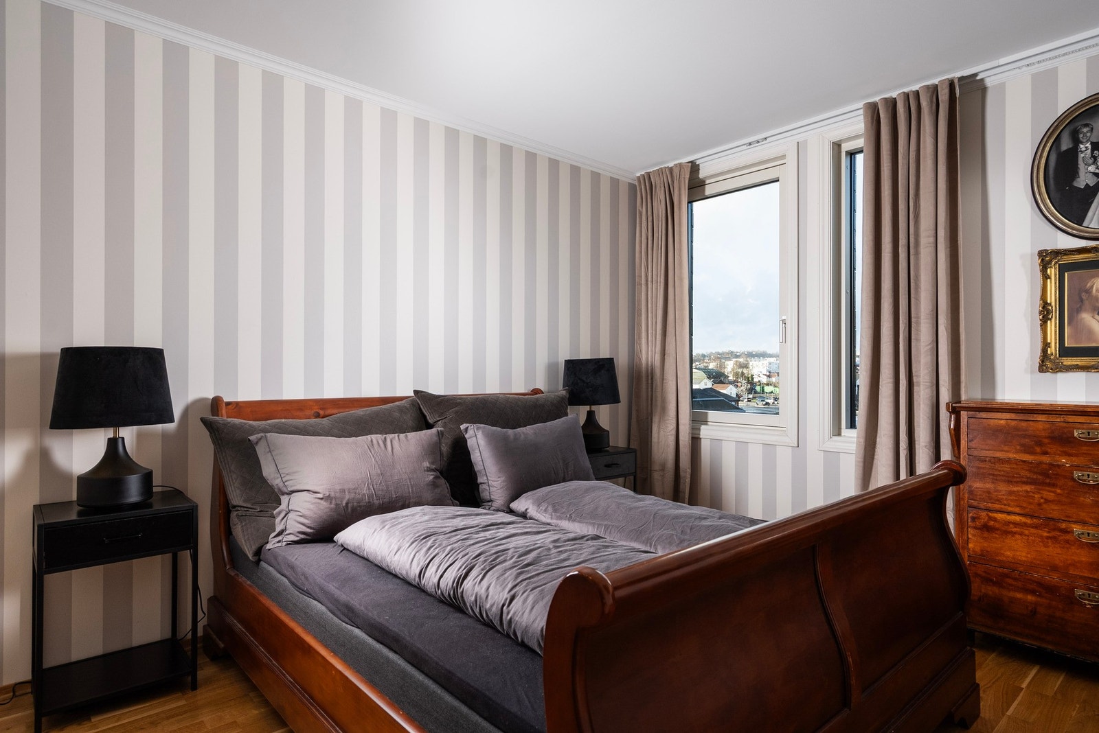 Elegant tapetsert hovedsoverom med gardinskinner montert helt opp mot taket - en detalj som gir rommet et eksklusivt og helhetlig preg Galleribilde